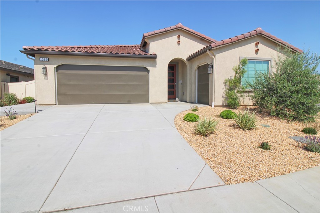 A rare find! This almost new home located in the 55+ Altis community is a real gem! No stone has been left unturned in the details and upgrades. The open floor plan features a large living room that over looks the kitchen. The island kitchen has stainless steel appliances including refrigerator, wall oven/microwave and gas cook top, granite counter tops, dark cabinetry, pendent lighting and walk-in pantry. Just off the living space is the primary suite with direct access to the backyard, walk-in closet and primary bath that features dual sinks and handicapped accessible walk-in shower. The secondary bedroom has a neighboring full bathroom. Open office/den located near the entry has open shelving and cabinetry. Inside laundry room has front loading washer and dryer included. This home also includes a great amount of closet storage, remote control window coverings throughout and plenty of recessed lighting. A resort like rear yard with full length patio cover that has recessed lighting and fan, built-in fire pit, water fountain, artificial turf and mature landscaped planters. The two car main garage has shelving, overhead storage, epoxy floors and electric vehicle charging station.