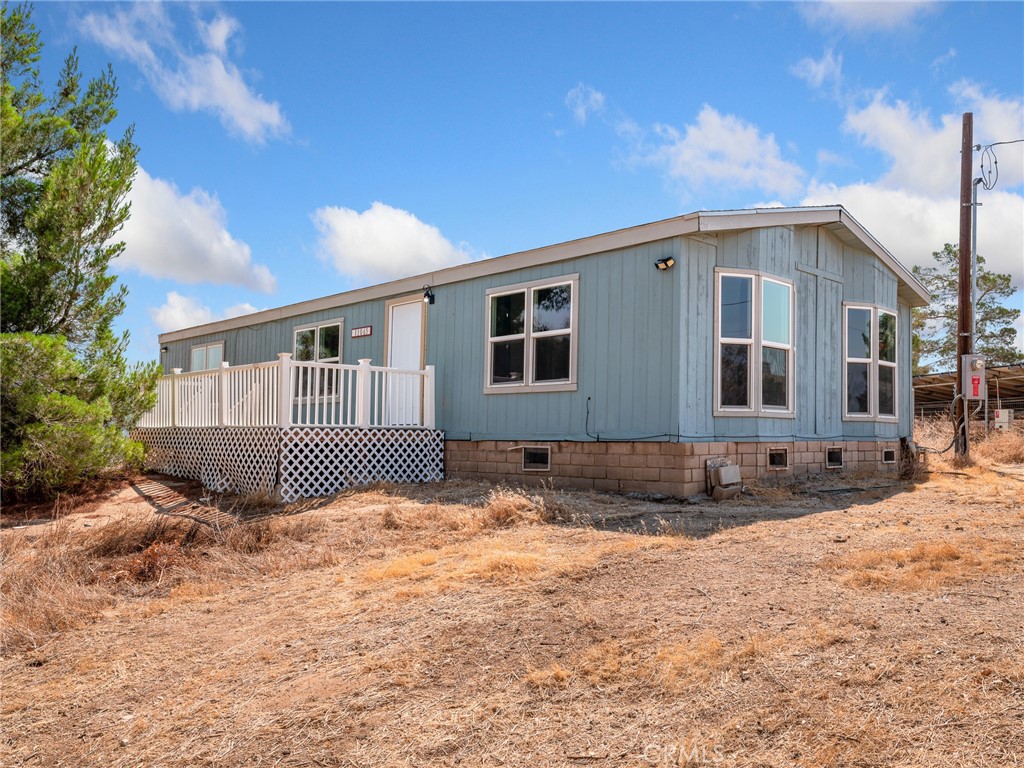 Move in ready 3 bedroom, 2 bath manufactured home with a redwood deck and open concept living that features a large 40X20 2 story barn as well as a detached oversized 2 car garage! This property was renovated with new fixtures and flooring a few years ago and has a brand new stove. The home sits on over 2 acres of level land and is completely fenced, has mature pine trees on the property creating a desert park like setting. The property comes with paid off solar to the benefit of the new owner. This property sits not too far off of pavement and has great views of the mountains to the southpectacular view of the mountains. Quick access to Phelan Rd for commuting, zoned for horses and located within the Snow Line School District.