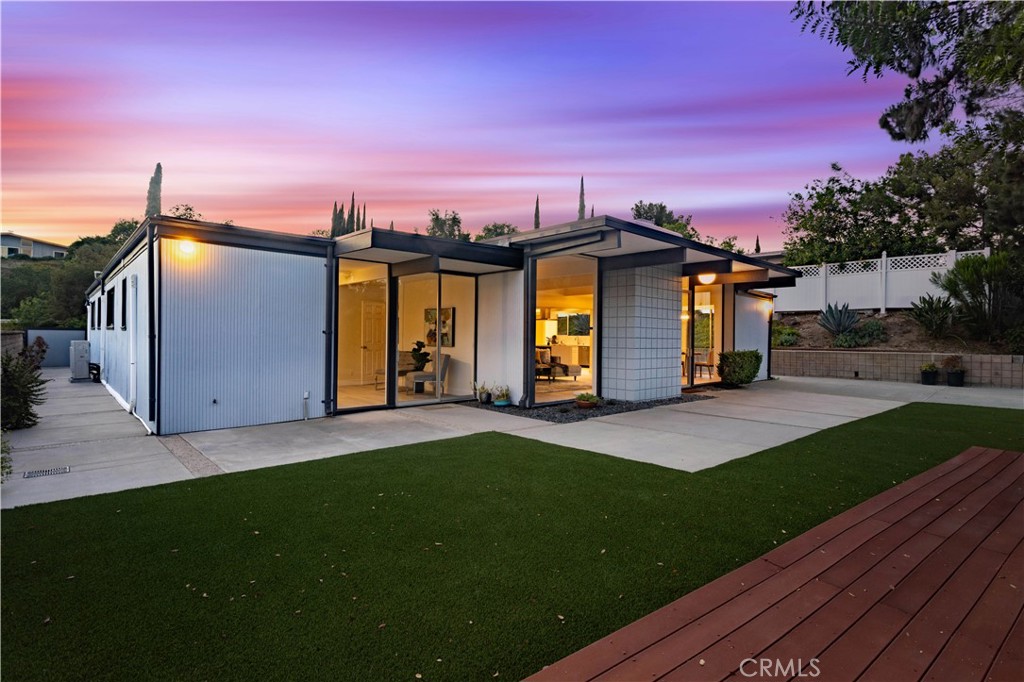 Dreaming of a totally updated mid-century modern home in Granada Hills with iconic architecture and open-concept living? This non-contributory Eichler home was originally designed by renowned architect A. Quincy Jones and has been completely remodeled with modern finishes while preserving its iconic charm. Featuring 4 bedrooms and 2 bathrooms, this light-filled home offers a massive great room with an ultra-open layout, brand-new kitchen with waterfall-edge quartz countertops, stainless steel appliances, subway tile backsplash, new cabinetry, an eat-in area, formal dining space, and a large island with room for stools. Enjoy multiple sitting areas, a cozy living room fireplace, new flooring throughout, and tons of recessed lighting. The primary suite includes a white wood ceiling, walk-in closet, and attached updated bathroom, while the three additional bedrooms share a beautifully remodeled hallway bath. There’s also an inside laundry area and an open, airy design with plenty of windows. Step outside to enjoy the low-maintenance backyard with artificial grass, a spacious deck, and multiple areas perfect for relaxing or entertaining outdoors. Located north of Rinaldi in Granada Hills, this mid-century modern home sits within the Balboa Highlands Historic Preservation Overlay Zone. Whether you're a fan of mid-century design, Eichler architecture, or simply moving to Granada Hills for its parks, hiking trails, top schools, or easy freeway access, this modernized Eichler-inspired home is not to be missed.