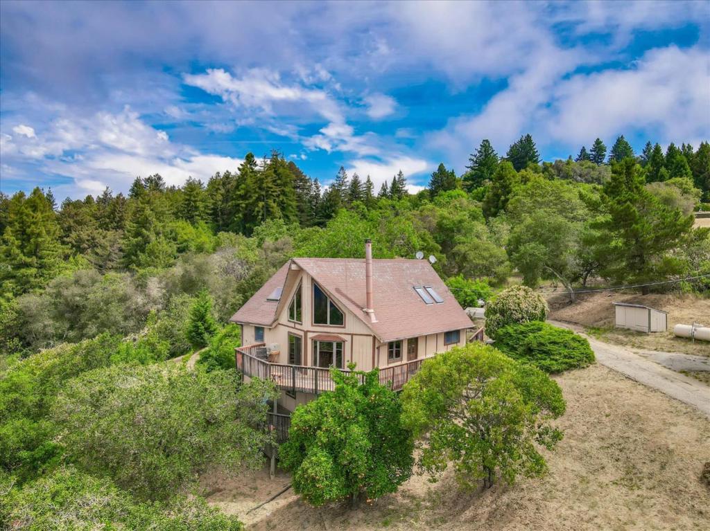 Enjoy gorgeous sunsets and views of the ocean from this wonderful 3.2 acre mountain retreat located on the highly-sought after Ocean View Road! Open, bright and inviting, this 3 bedroom 2 bathroom A-Frame offers plenty of character. The bonus lower level has tremendous flexibility as a bedroom and/or office with an additional 3rd full bath and walk-in closet! The open kitchen includes a breakfast bar, electric double oven, gas range with down draft exhaust, recessed lighting, a generous skylight, plenty of storage and gorgeous views. The master bedroom features an oversized bathroom, walk-in closet, and private balcony. The spacious loft makes a great separate living room or study. High-quality dual pane Anderson Windows, front-load washer and dryer, wood-burning stove, wrap around deck, an abundance of extra storage, and a detached 2 car garage. Highly-rated schools - Loma Prieta Elementary, CT English Middle, Los Gatos High, and only about a 20 min drive to Downtown Los Gatos!