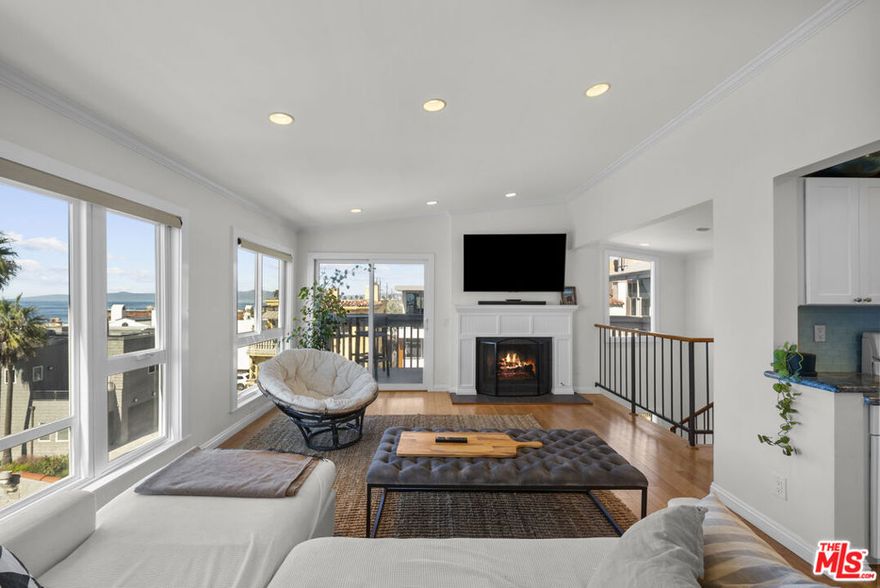 Located in the heart of Manhattan Beach's Sand Section, one block from the ocean, this walk-street home showcases sweeping 180-degree coastline views and outdoor space on every level. This three-level residence spans approximately 2,700 square feet with three bedrooms and three bathrooms and centers daily life around an oversized first-floor patio complete with a fire pit for effortless indoor/outdoor living and entertaining. Upon entry, a formal foyer leads to a comfortable living space with fireplace and french doors open to the walk-street patio with ample seating and direct ocean outlooks. In addition, the main floor level includes a bedroom or flex room, a full bathroom and a dedicated laundry room. The second floor offers two private bedrooms separated by a full bathroom. The primary bedroom captures ocean views and opens to a large balcony for fresh air and morning light. The top level crowns the residence with head-on ocean views and abundant natural light, open living space, a gas fireplace, chef's kitchen with high-end appliances and a dedicated dining area plus an additional balcony extends the living space outdoors. A private two-car garage with generous storage easily accommodates boards, bikes and beach gear. This is the front residence within a detached two-home property (no common walls). Recent improvements include new windows, a new roof with copper flashing, central heating, a gas range and gas fireplaces. The location provides convenient proximity to The Strand, the Pier, cafes, boutiques, dining and sought-after local schools.