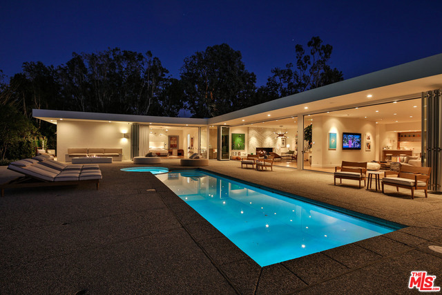 This completely renovated Mid-Century contemporary was redesigned by world-renowned designer Trip Haenisch. Finished with the finest materials and the latest and greatest amenities, this estate is an entertainer's dream. Beautiful serene canyon & city views, seamless indoor/outdoor floor plan. A large oversized master suite includes a separate office/T.V. room and individual his & hers master baths & closets. The kitchen area includes Miele appliances and Italian marble in addition to the 200+ bottle wine cellar & butler's pantry. Italian Carrera marble and bleached wide plank oak floors throughout, brass fixtures throughout and custom Italian cabinets & closets. Other amenities include three fire pits, a cabana, two fireplaces, pool & spa and two bars. The home also features a three-car garage and oversized motor court.