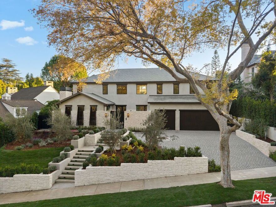 Exceptional custom residence blending contemporary sophistication with timeless elegance. Interiors feature wide-plank oak floors, natural wood elements, and a refined mix of slab finishes and custom cabinetry. The chef's kitchen is appointed with Sub-Zero refrigeration, Bluestar range, and a Miele espresso maker, opening to a soaring family room with double-height ceilings and walls of glass.  Resort-style outdoor living includes a pool, ADU, built-in BBQ and beverage center, fire pit beneath the pergola, and landscaped grounds with a private entry water feature. Additional highlights: state-of-the-art theater, finished basement with gym, temperature-controlled wine cellar, home automation, elevator to all levels, two laundry rooms, a second Miele espresso maker in the primary suite, and three-car garage.  A rare opportunity to own a thoughtfully designed estate offering luxury, comfort, and style in one of Los Angeles' most coveted neighborhoods.