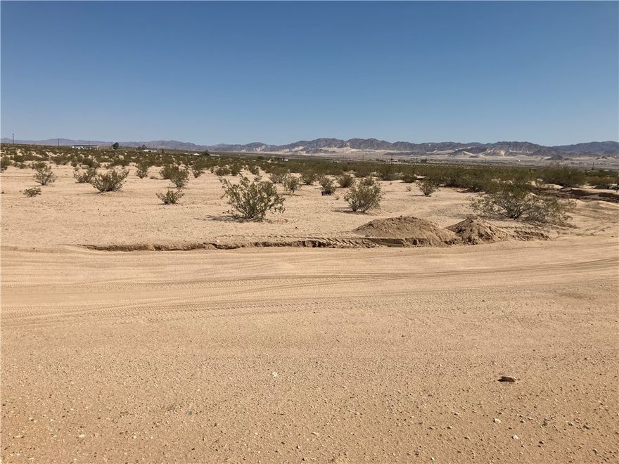 Enjoy the peace and quiet of Hi-Desert living!  This Flat 5 Acre Parcel has water access and is located on a Very Desirable Corner Lot. Panoramic blue skies with amazing sun rises and beautiful starry nights is very inviting with close proximity to Joshua Tree National Park. Take a look!!