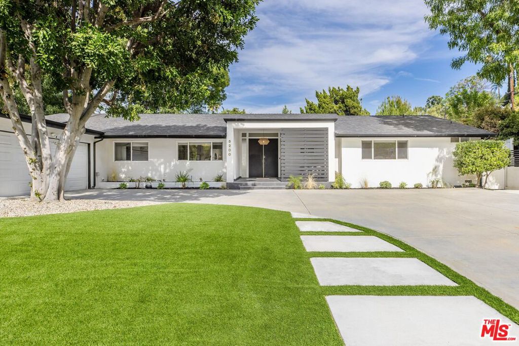 Welcome to this stunningly reimagined single-story residence, perfectly located in one of Woodland Hills' most sought-after neighborhoods. This 4BD/3.5BA home has been thoughtfully renovated from top to bottom, blending timeless design with modern sophistication. Step inside to a sun-drenched open floor plan where natural light floods the spacious living room, seamlessly connecting to the dining area, ideal for entertaining family and friends. The chef's kitchen is a showstopper, featuring gleaming quartz countertops, generous prep space, and a massive center island that anchors the heart of the home. Just off the kitchen, a dedicated office with built-in desk and storage makes working from home a breeze. The expansive primary suite is a true retreat, complete with a cozy fireplace, custom walk-in closet, and a spa-inspired bath featuring a wet room with soaking tub, shower, and dual vanities. A secondary ensuite bedroom offers privacy and comfort for guests, while the remaining two bedrooms share a beautifully updated Jack-and-Jill bath with designer finishes. Out back, the fully landscaped yard is made for entertaining with a spacious patio, built-in BBQ, and plenty of room to relax or play. All this is just moments from the best dining and shopping along Ventura Blvd, with easy access to the Westside. Don't miss the chance to own this exceptional home that checks every box for style, comfort, and location.