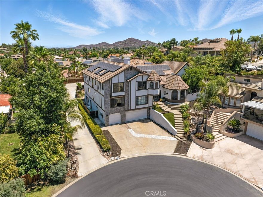 MASSIVE PRICE IMPROVEMENT! This estate offers an impressive interpretation of one-of-a-kind. Just a short walk away from the Lodge & on one of the most popular cul-de-sac's for kids to enjoy Halloween & parade festivities, this expansive home offers a sparkling pool/spa, two-story primary bedroom, 4 car tandem garage, over $300K in upgrades & 75 OWNED solar panels installed in 2022! Being an all-electric community, this home runs on energy efficiency & even has a separate propane tank for the pool/spa. Entering the stylish custom double doors, you are greeted with a view of a stunningly remodeled home with a sizeable living area open to the formal-style dining room with overhead accent beams on the vaulted ceiling as well as a second floor bridge designed for elegance & convenience when walking from your second floor primary bedroom to the upstairs loft. The tile plank floor is a show-stopper on this level & it adds to the overall spectacular feeling when entering. To the left of the main floor living room is a secondary living space complete with fireplace & open to the kitchen, casual dining nook & island. The kitchen has been completely remodeled with custom soft-close cabinets & granite countertops with an oversized island, dual-door fridge & ample windows & sliding door for a perfect view of the pool/backyard. A full bedroom & bathroom (perfect for mother-in-law quarters or guests) are on this floor along with a large laundry room. The south-wing primary bedroom is TWO STORY & the main floor offers a serene primary living room with a walk-in closet while the second floor offers the remodeled primary bedroom & bathroom which includes a custom shower & dual sinks with upgraded fixtures. Walking across the bridge leads you to the north-wing entering your THIRD living room where your guests/kids can enjoy their own space. Also, 4 bedrooms that are sizable which also share 2 additional full bathrooms that are also remodeled. Downstairs on the garage level is a 4 car tandem garage AND an additional TWO ROOMS totaling approximately 1,500 square feet! One is a utility room with sink and the other is currently used as a gym/storage which can easily be converted to an ADU with outside access. Imagine the possibilities with all this extra space! Almost all the electrical was redone along with new fixtures, paint, flooring and so much more to make this move-in ready.  Jump in the pool/spa and enjoy your covered patio for the best in entertaining and relaxing!