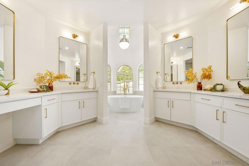 Stunning Fully Renovated Single-Story Corner Lot Home with Designer Touches Throughout Welcome to this brand-new, meticulously renovated single-story home, ideally situated on a spacious corner lot. From the moment you step inside, you’ll be captivated by soaring wood-vaulted ceilings, an elegant updated chandelier, and wide-plank engineered hardwood flooring that flows seamlessly throughout. The grand entrance leads into a warm and inviting family room, perfectly positioned with direct access to your own private oasis—complete with a sparkling pool and relaxing jacuzzi. The expansive primary wing is a luxurious retreat, featuring an executive office, a tranquil atrium, and an impressive ~1,000 sq ft primary suite. The spa-inspired primary bathroom boasts dual-head showers, his-and-hers vanities, dual walk-in closets, and a freestanding tub beneath a stunning overhead light fixture and vaulted wood ceiling. The chef’s kitchen is a showstopper with custom soft-close slim shaker cabinetry, marbled quartz countertops, and a pearl tile backsplash extending to the ceiling. The adjoining wet bar is equally refined, creating a perfect space for entertaining. The north wing includes a second serene atrium and two well-appointed bedrooms connected by a luxurious Jack-and-Jill bath featuring a shared overhead shower and a freestanding soaking tub. A fourth bedroom includes its own private ensuite and matching custom cabinetry. Additional features include new paint, baseboards, dual AC, and a brand new roof! This turnkey property is the perfect blend of modern luxury and custom design