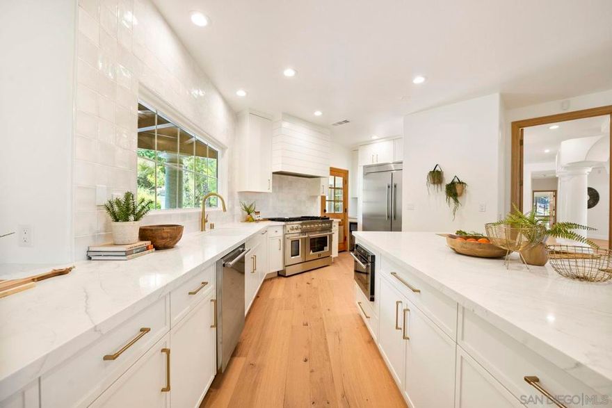 Stunning Renovated Single-Story Corner Lot Home with Designer Touches Throughout. This single-story home, ideally situated on a spacious corner lot. From the moment you step inside, you’ll be captivated by soaring wood-vaulted ceilings, an elegant updated chandelier, and wide-plank engineered hardwood flooring that flows seamlessly throughout. The grand entrance leads into a warm and inviting family room, perfectly positioned with direct access to your own private oasis—complete with a sparkling pool and relaxing jacuzzi. The expansive primary wing is a luxurious retreat, featuring an executive office, a tranquil atrium, and an impressive ~1,000 sq ft primary suite. The spa-inspired primary bathroom boasts dual-head showers, his-and-hers vanities, dual walk-in closets, and a freestanding tub beneath a stunning overhead light fixture and vaulted wood ceiling. The chef’s kitchen is a showstopper with custom soft-close slim shaker cabinetry, marbled quartz countertops, and a pearl tile backsplash extending to the ceiling. The adjoining wet bar is equally refined, creating a perfect space for entertaining. The north wing includes a second serene atrium and two well-appointed bedrooms connected by a luxurious Jack-and-Jill bath featuring a shared overhead shower and a freestanding soaking tub. A fourth bedroom includes its own private ensuite and matching custom cabinetry. Additional features include new paint, baseboards, dual AC, and a brand new roof! This turnkey property is the perfect blend of modern luxury and custom design