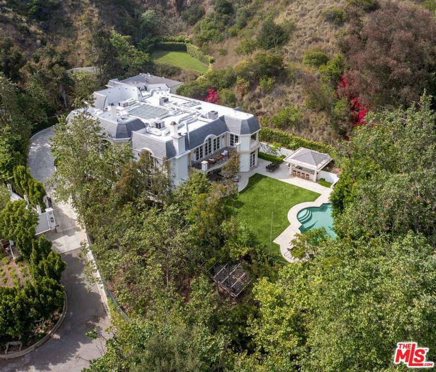 INCREDIBLE VALUE IN BEL AIR ON 1.5 ACRES - CONTEMPORARY EUROPEAN ESTATE. Up a long, gated driveway at the end of a picturesque cul-de-sac, off the coveted Stone Canyon, you'll find this stunning contemporary estate that sits on over one and a half acres of land. A sprawling motor court that can accommodate parking for up to 15 cars, with a grand 6-car garage highlighting the villa. Encompassing 11,251 square feet, the estate boasts 7 bedrooms and 9 bathrooms, a two-story entry, living room, dining room, an elevator, a formal library, dual powder rooms, a second-floor family area, and an expansive gourmet kitchen with a double island adorned with granite counters. The kitchen also features a breakfast room with French doors opening to the lush and private grassy lawn, as well as the inviting pool/spa and cabana. The lot includes a second lawn area with striking mountain views, which could be converted into sports courts, making this property truly extraordinary. The estate offers a great floor plan, ideal for both comfortable living and elegant entertaining. Very private and rarely does a property of this scale become available, priced aggressively to sell.