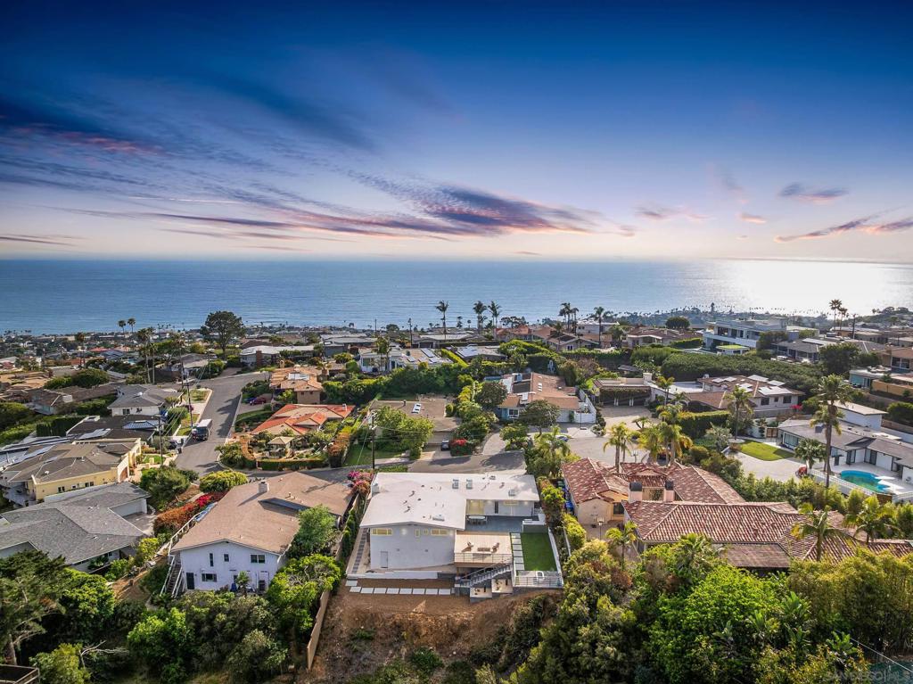 Welcome to 5851 Box Canyon, a fully reimagined La Jolla ocean view single-level home blending timeless mid-century modern design with today’s luxury updates. Tucked away on a private cul-de-sac, this residence offers panoramic Pacific Ocean views, seamless indoor-outdoor living, & the rare combination of privacy, space, & convenience. Step through a custom front solid oak pivot door into an open, light-filled sanctuary with vaulted ceilings, skylights, and expansive sliders framing sweeping coastal vistas. A striking curved fireplace anchors the living space with warmth and architectural style. The chef’s kitchen features rift-cut oak cabinetry, Caesarstone counters, dual dishwashers, & terrazzo floors, flowing effortlessly into the backyard. Terraced outdoor spaces include a full outdoor kitchen, oversized deck, fire pit, & multiple seating areas. The large lot offers room for a pool, ADU, or multi-generational living, an increasingly rare opportunity in La Jolla real estate. Thoughtfully designed landscaping boasts native plants, blending beauty with sustainability. Designer finishes continue throughout with custom cabinetry, slate patio, sustainable turf, and curated lighting. The spa-inspired primary suite includes a wet room with dual showers and a soaking tub, while additional flexible space is ideal for a home office, gym, or wine cellar. A turnkey La Jolla luxury retreat invites you to enjoy California coastal living at its finest, whether it is morning coffee on the front patio, sunset dinners overlooking the Pacific, or relaxing in your private canyon sanctuary. Welcome to 5851 Box Canyon, a fully reimagined La Jolla ocean view single-level home blending timeless mid-century modern design with today’s luxury updates. Tucked away on a private cul-de-sac, this residence offers panoramic Pacific Ocean views, seamless indoor-outdoor living, & the rare combination of privacy, space, & convenience. Step through a custom front solid oak pivot door into an open, light-filled sanctuary with vaulted ceilings, skylights, and expansive sliders framing sweeping coastal vistas. A striking curved fireplace anchors the living space with warmth and architectural style. The chef’s kitchen features rift-cut oak cabinetry, Caesarstone counters, dual dishwashers, & terrazzo floors, flowing effortlessly into the backyard. Terraced outdoor spaces include a full outdoor kitchen, oversized deck, fire pit, & multiple seating areas. The large lot offers room for a pool, ADU, or multi-generational living, an increasingly rare opportunity in La Jolla real estate. Thoughtfully designed landscaping boasts native plants, blending beauty with sustainability. Designer finishes continue throughout with custom cabinetry, slate patio, sustainable turf, and curated lighting. The spa-inspired primary suite includes a wet room with dual showers and a soaking tub, while additional flexible space is ideal for a home office, gym, or wine cellar. A turnkey La Jolla luxury retreat invites you to enjoy California coastal living at its finest, whether it is morning coffee on the front patio, sunset dinners overlooking the Pacific, or relaxing in your private canyon sanctuary. Solid OakCabinetry; Caesarstone Countertops; Kohler and Bosh Fixtures and Appliances; Zia Tile; Riad Tile; Terrazzo Tile; Timbertech Front and Back Deck; BrazilianSlate Tiled Patio; PFAS Free Turf; Succulent Garden; Custom Aluminum Railings by Mulholland Brand; Custom Pivot Door by The Pivot Door Company; BlueDot Lighting Fixtures; Rich Brilliant and Willing Light Fixtures; Toto Toilets; Custom Hallway Transom Window