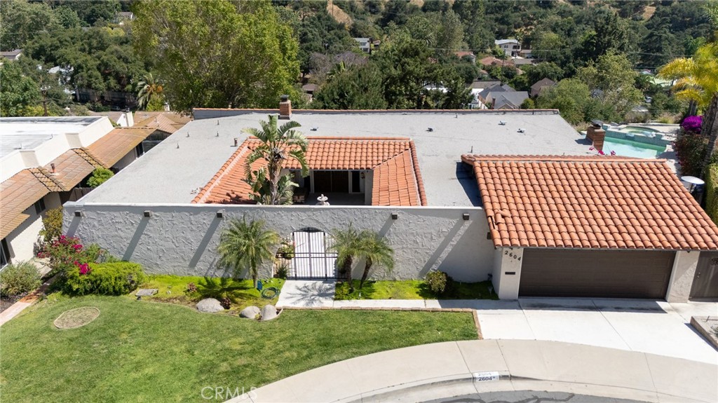Welcome to Luxurious Living in Glenoaks Canyon! Nestled in a tranquil cul-de-sac with a picturesque island centerpiece, this stunning single-level Hacienda-style home offers a harmonious blend of charm, comfort, and sophistication. Located in one of Glendale’s most coveted neighborhoods, surrounded by serene mountain views, long-term neighbors, and celebrity residences, this property is truly exceptional. As you arrive, you’re greeted by a beautifully landscaped front courtyard featuring a soothing water fountain, desert plants, and ambient lighting, setting the tone for the elegance that lies within. The thoughtfully designed interior showcases a seamless flow of hardwood and Saltillo tile flooring, energy-efficient dual-paned windows, a sunken living room perfect for entertaining, and a convertible den with a closet that serves as a versatile fourth bedroom. The family room exudes warmth with two fireplaces, plantation shutters, and French doors that invite natural light. The remodeled Chef’s Kitchen is a culinary masterpiece, boasting high-end stainless steel appliances, granite countertops, a breakfast bar, and a casual dining area that opens to a cozy den. A formal dining room adds a touch of sophistication for hosting elegant gatherings. This home features four spacious bedrooms, including a luxurious primary suite with direct backyard access and breathtaking canyon views. The en-suite bathroom offers a spa-like retreat with a step-down soaking tub and premium finishes. All bathrooms have been meticulously remodeled with modern designs and high-end fixtures. The backyard is an entertainer’s dream, highlighted by a striking infinity pool and spa, a built-in BBQ, a large patio, and a flat grassy yard. Unobstructed canyon views provide a million-dollar backdrop, perfect for both relaxation and celebration. Located within the prestigious Glenoaks Elementary School boundaries and Glendale Unified School District, this home offers proximity to Scholl Canyon Park, hiking and mountain biking trails, the Glendale Sports Complex, Occidental College, and Glendale Community College. Don’t miss this rare opportunity to lease one of Glenoaks Canyon’s finest residences.