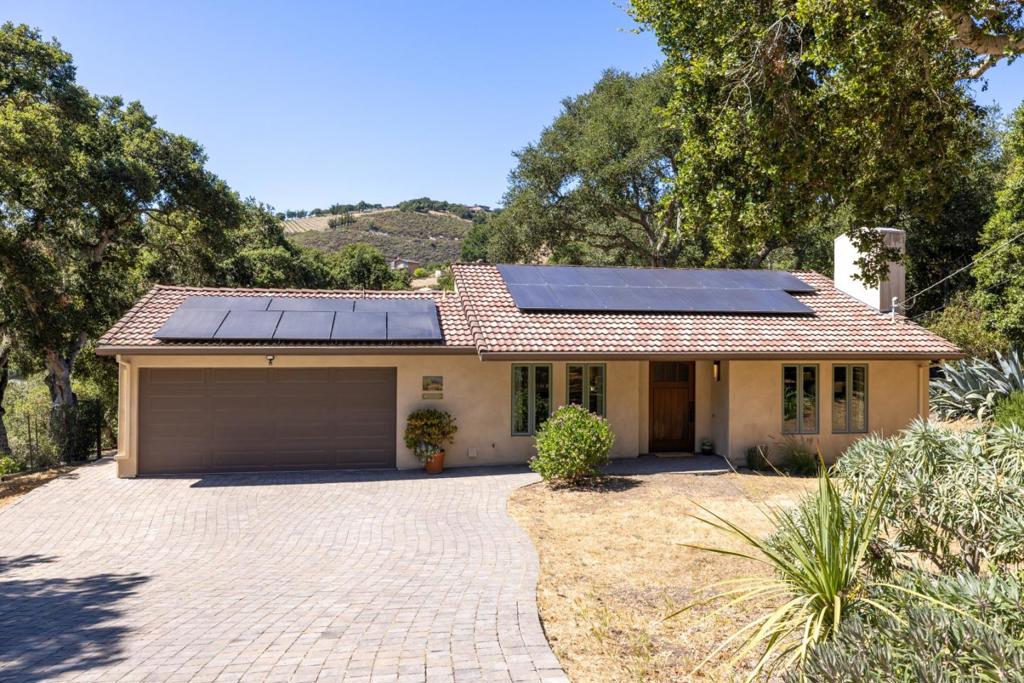 Although this fascinating home on two-and-a-half acres of golden land conveys a beautiful sense of remoteness and tranquility amid nature, it is within easy reach of anywhere you want to explore on the Monterey Peninsula. Its prime position within the Hidden Hills community of Carmel Valley places it midway between the Monterey-Salinas Highway 68 corridor and the base of Carmel Valley. Once inside, notice your gaze drawn instantly upward by an elegantly rustic, pitched ceiling meeting the top of a kiva-inspired wood-burning fireplace in the living room. Pass through an informal dining area to enter a gourmet chef's kitchen that features a center island with a chic, light wood countertop. Rich wood flooring runs throughout nearly every room of this three-bedroom dwelling with a calm, elemental Southwestern spirit that melds gorgeously with the surrounding countryside. Outside on an expansive, oak-enclosed patio, sink into the soothing waters of a spa tub as you breathe in the revitalizing scents of earth and trees. A separate yurt waits at the hill's edge, serving as a bonus room. Might it be your yoga studio? Or, perhaps, a library or private guest retreat? Here is a property that has mastered the art of versatility, and done so in a way that feels at once artful and profound.