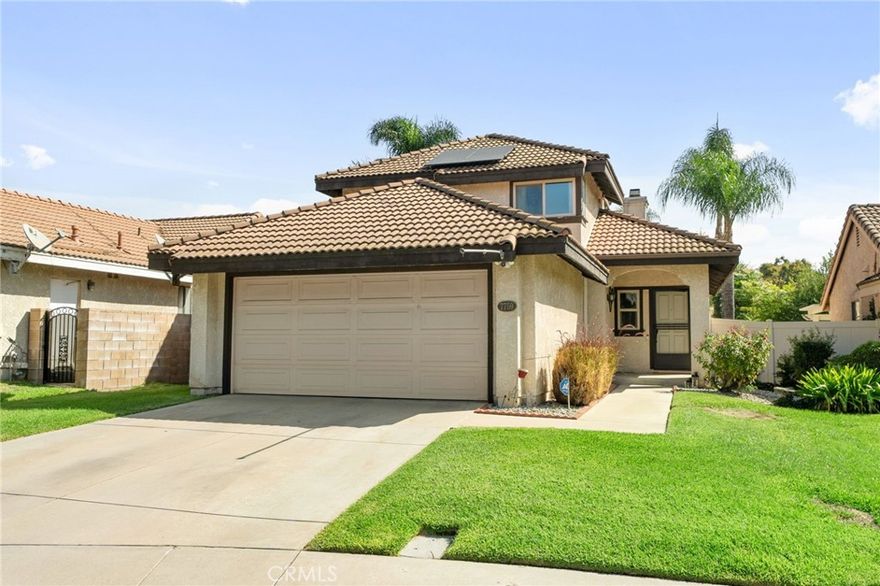 This charming home at the end of the cul de sac offers incredible curb appeal with lush green grass and beautiful landscaping that welcomes you in. Step inside to a spacious family room featuring a cozy fireplace, high ceilings, and an open-rail staircase. Sliding glass doors lead to the backyard, filling the space with natural light. The kitchen includes a cheerful breakfast nook, upgraded cabinets, quartz countertops, and a stylish tile backsplash. Conveniently, there’s a downstairs bedroom and a full bathroom—perfect for guests or multi-generational living—plus an indoor laundry room. Upstairs, the primary suite features dual sinks and plenty of space to unwind, along with another comfortable bedroom. This home also boasts new windows throughout for energy efficiency and comfort, along with solar panels for added savings! Outside, the backyard is an entertainer’s delight with a covered patio, lush lawn, palm trees, and a fenced side yard—ideal for play or pets. Located close to parks, shopping, and top-rated schools, this home truly has it all!