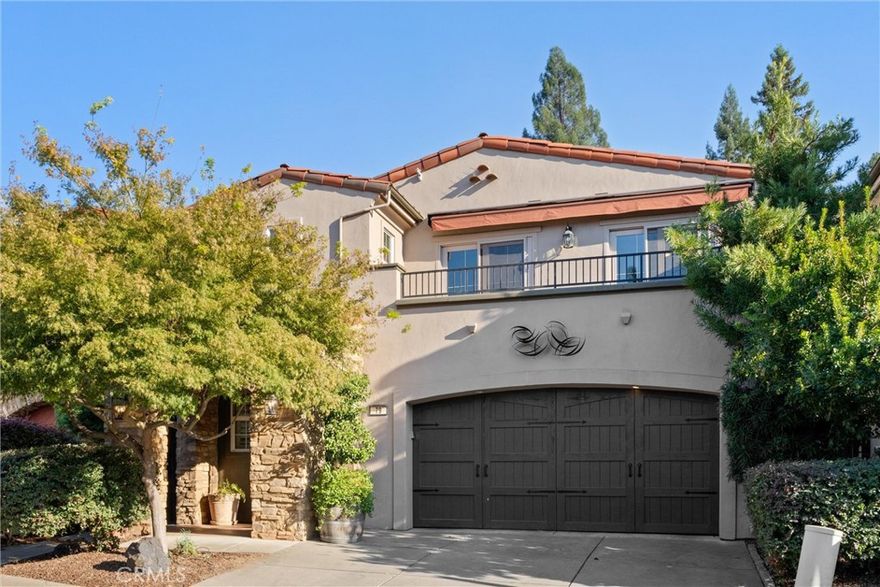 Welcome to 79 Veneto Circle, nestled in the prestigious Sorento community, where timeless elegance meets modern comfort. Step through a grand entry framed by graceful archways and soaring ceilings into a home rich with architectural beauty and refined finishes. Elegant window shutters, custom ceiling fans, and designer lighting enhance every space. This luxurious two-story residence offers 3 bedrooms, 2.5 baths, an open upstairs office, and two primary suites. The upstairs primary features a private balcony with designer wrought-iron railing, a large custom-tiled shower, dual sinks, and elegant lighting. A guest bedroom shares the balcony, while the third bedroom provides cozy comfort. The downstairs spacious primary suite offers a private retreat with high ceilings, an oversized walk-in closet, walk-in shower, soaking tub, and direct access to the tranquil patio with a built-in outdoor bar—perfect for morning coffee or evening relaxation. The living room exudes warmth with a gas fireplace and airy ambiance. The chef’s kitchen is a dream come true with rich cherry wood cabinetry, granite countertops, a large island, breakfast bar, walk-in pantry, and solar tube lighting. Additional highlights include a designer wrought-iron staircase, finished two-car garage, newer HVAC, dual mini-split systems, and a tankless water heater. The backyard oasis offers shaded trees, flower beds, and peaceful charm. Experience luxury and sophistication at 79 Veneto Circle—a true Sorento gem.
