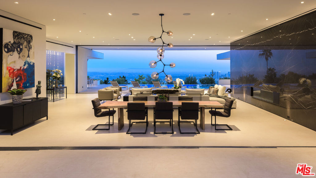 Perched atop one of Trousdale's most prestigious streets, this contemporary one-story estate designed by acclaimed architecture firm XTEN offers sweeping, unobstructed views from Downtown Los Angeles to the Pacific Ocean. Spanning nearly 7,000 square feet on a single level, this home is the epitome of refined indoor/outdoor living. Floor-to-ceiling Fleetwood glass walls seamlessly disappear at the touch of a button, blurring the line between interior sophistication and the natural beauty beyond. Crafted with the finest materials and meticulous attention to detail, the residence features five luxurious bedrooms and six bathrooms, each finished to the highest standard. A dramatic arrival experience begins with a gated motor court and a custom water feature that leads to an awe-inspiring glass entryway. Inside, the open-concept floor plan is accentuated by soaring ceilings, bespoke nine-foot solid hardwood doors, and walls of glass that flood the space with natural light. Amenities abound, including a stunning home theater, a fully-equipped secondary prep kitchen, a Control4 smart home system, and a temperature-controlled 1,000-bottle glass wine cellar. The landscaped backyard is a private sanctuary, featuring a built-in fireplace lounge and panoramic vistas that redefine entertaining at elevation. This is a rare opportunity to own a world-class architectural home at an exceptional value. Shown to pre-qualified clients only.
