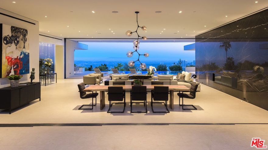 Perched atop one of Trousdale's most prestigious streets, this contemporary one-story estate designed by acclaimed architecture firm XTEN offers sweeping, unobstructed views from Downtown Los Angeles to the Pacific Ocean. Spanning nearly 7,000 square feet on a single level, this home is the epitome of refined indoor/outdoor living. Floor-to-ceiling Fleetwood glass walls seamlessly disappear at the touch of a button, blurring the line between interior sophistication and the natural beauty beyond. Crafted with the finest materials and meticulous attention to detail, the residence features five luxurious bedrooms and six bathrooms, each finished to the highest standard. A dramatic arrival experience begins with a gated motor court and a custom water feature that leads to an awe-inspiring glass entryway. Inside, the open-concept floor plan is accentuated by soaring ceilings, bespoke nine-foot solid hardwood doors, and walls of glass that flood the space with natural light. Amenities abound, including a stunning home theater, a fully-equipped secondary prep kitchen, a Control4 smart home system, and a temperature-controlled 1,000-bottle glass wine cellar. The landscaped backyard is a private sanctuary, featuring a built-in fireplace lounge and panoramic vistas that redefine entertaining at elevation. This is a rare opportunity to own a world-class architectural home at an exceptional value. Shown to pre-qualified clients only.