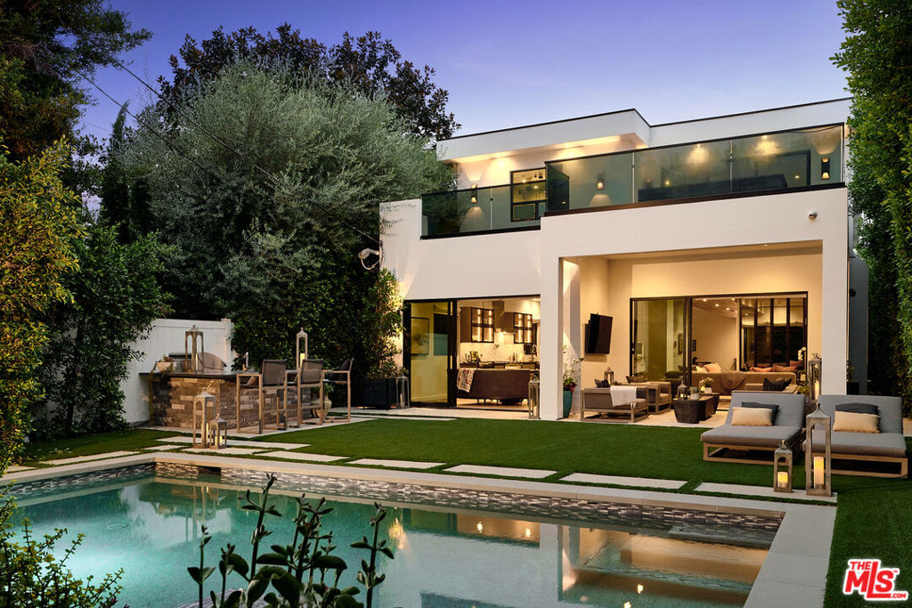 Ideally situated in prime Brentwood and thoughtfully tucked away, this newer-construction estate offers a rare blend of elegance, sophistication, and privacy, providing a serene setting that feels worlds apart despite its central location. A dramatic entry sets the stage for the 6-bedroom, 7-bath residence, where soaring ceilings, an abundance of natural light, and sleek lines are softened by carefully curated finishes. Designer-done throughout, the open-concept floor plan is both modern and inviting, framed by Fleetwood sliding doors that epitomize Southern California's seamless indoor-outdoor lifestyle. The gourmet chef's kitchen is masterfully appointed with Miele appliances and an oversized island, opening to a more intimate living area that flows effortlessly to the backyard. This private outdoor oasis is fully hedged and landscaped for complete seclusion, with a heated pool and spa surrounded by lush greenery, an idyllic retreat for entertaining or relaxation. A personal elevator services all three levels. Upstairs, three spacious en-suite bedrooms complement the primary retreat, a sanctuary featuring a fireplace, spa-like bath with soaking tub and steam shower, a custom walk-in closet, and an oversized private terrace overlooking the garden, perfect for morning coffee or evening sunsets. The lower level is designed for elevated living and entertainment, complete with a state-of-the-art home theater, wine closet, full bar, and gym. Meticulously built and thoughtfully styled, this residence embodies the best of both worlds: dramatic modern design, warmed by elegant details, and private, peaceful living just moments from the Brentwood Country Mart, fine dining, boutique shopping, and all the Westside has to offer.