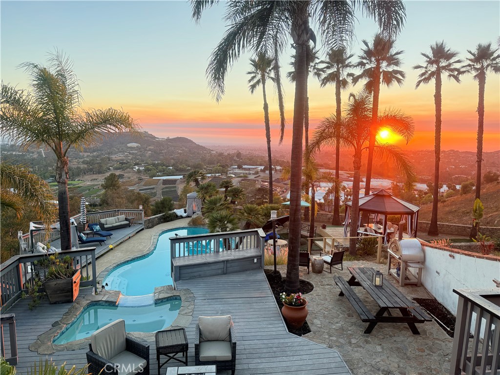 Perched to capture sweeping panoramic ocean views, this exceptional estate is a masterclass in luxury and craftsmanship. Completely remodeled with no expense spared, the interior boasts gleaming marble floors, a dramatic stone fireplace, and an open-concept floor plan ideal for modern living and entertaining. The chef's kitchen features top-of-the-line appliances and elegant stone countertops, seamlessly flowing into expansive living and dining areas. The stunning primary suite is a true sanctuary, complete with a spa-inspired bathroom featuring a soaking tub, massive his-and-her closets, and private access to multiple view decks that showcase breathtaking sunsets and coastal breezes. Outside, the home is enveloped by hundreds of feet of hand-built stone walls, providing unmatched privacy and a sense of timeless grandeur. The resort-style backyard is a dream, offering a sparkling pool with a concrete slide, relaxing spa, shaded gazebo, turf lawns, and dozens of sowing palm trees. This serene retreat is further enhanced by its bucolic charm, including multiple family fruit trees scattered across the grounds. Whether you're lounging poolside, enjoying the ocean breeze from one of the decks, or walking the beautifully landscaped property, this home delivers peace, privacy, and unparalleled coastal living.