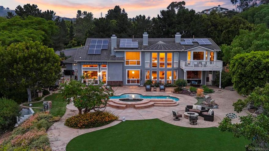 Stunning and serene, this two-acre estate is nestled at the end of a private cul-de-sac in Knightsbridge Country Estates, one of Olivenhain’s premier gated communities. With sweeping southwest views, this 5,500+ sq ft home showcases quiet luxury with timeless design, classic architecture, and flexible living spaces. A dramatic dual staircase entry opens to a light-filled living room with expansive windows. The main level includes a guest suite with private entrance, formal living and dining rooms, a family room, and a custom wine room. The gourmet kitchen features stainless steel appliances, a large island, and a butler’s pantry. Upstairs offers a view-filled primary suite with balcony and dual-sided bath, plus three bedrooms and a bonus room. Resort-style amenities include a pool, two detached studios, an oversized four-car garage, owned solar, and full city services.  A dramatic dual staircase entry sets the tone for the interiors, opening into a soaring, light-filled living room framed by expansive windows that highlight the home’s southern exposure and unobstructed views. The main level includes a guest bedroom with private entrance and full bath, ideal for multigenerational living or a home office, along with formal living and dining areas, a family room, and a custom wine room. The gourmet kitchen features stainless steel appliances, a large center island, and a butler’s pantry, flowing seamlessly into the family room and outdoor BBQ area. Upstairs, the primary suite boasts a private balcony, walk-in closet, and a luxurious dual-sided bath. Three additional bedrooms and a flexible bonus room complete the upper level. Resort-style amenities include a sparkling pool, two detached studio/gym structures, an oversized four-car garage, owned solar, and full city services (sewer, water, streets).