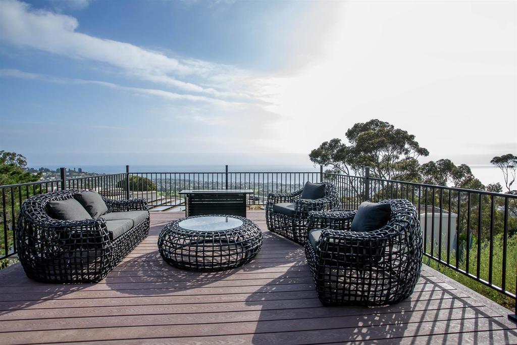La Jolla's "King of the Hill" Stunning View property and vacation home in upper Country Club, move in ready! Fully furnished and just remodeled with mid-century modern designer finishes. Enjoy year round entertainment and unobstructed ocean views from every vantage point. Featuring, an enclosed and expansive turf yard for private parties; wellness center with cold plunge spa, sauna, sun deck, wrap around porch, BBQ and dining area. The ocean view great room opens up to the formal dining room and galley kitchen with coffee & wine bar. Three generous king-sized ensuite bedrooms with personal TV's, welcome your guests with cozy linens and sunset views. Formal powder room, laundry and mud room with 2 car garage complete this unique compound. Property abuts to the La Jolla Park, 46 acre reserve and hiking trails down to the village and beach.