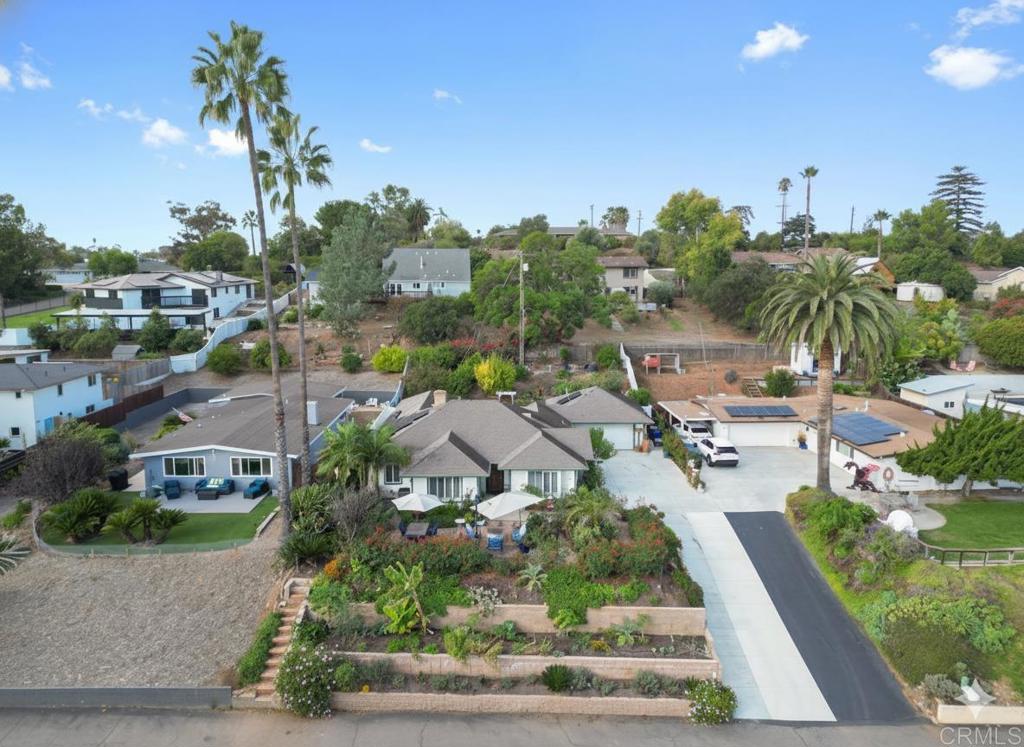 Discover timeless charm and modern comfort in this beautifully upgraded custom home, perfectly situated near the heart of downtown Vista! Perched on a gentle hill, the home captures sweeping views of the surrounding hills and twinkling city lights, creating a serene backdrop for relaxation and gatherings. Thoughtfully enhanced while preserving its original character, this residence features a spacious family room with cathedral ceilings, exposed wood beams, and a stunning rustic brick fireplace. The upgraded kitchen offers granite counters, stainless steel appliances, and a wine fridge—perfect for both everyday living and entertaining. Set on a large, landscaped lot, the property includes multiple outdoor seating areas and a fenced orchard filled with mature fruit trees, providing a private retreat to enjoy the outdoors. Leased solar adds efficiency, while the desirable location offers easy walkability to Vista’s restaurants, theaters, and shops. A true blend of craftsmanship, warmth, and convenience!