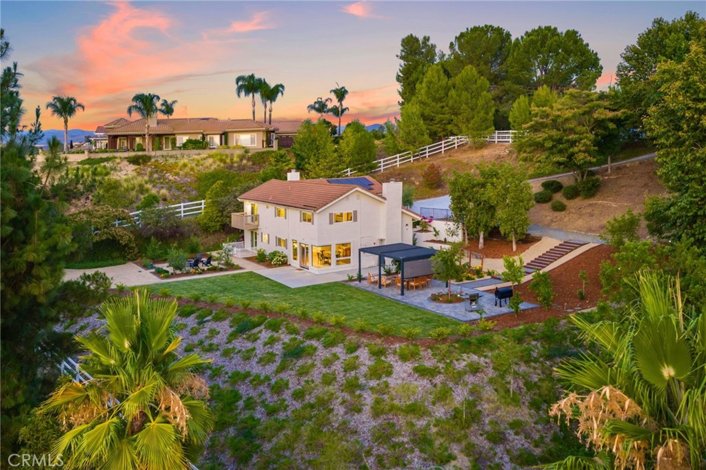 BEAUTIFULLY REMODELED MEADOWVIEW RETREAT IN THE HEART OF TEMECULA! With OWNED SOLAR and nearly 3/4 of an acre of space, this home is a rare find. Step inside to an open-concept floor plan framed by SENSATIONAL POSTCARD VIEWS that will take your breath away. The fully remodeled kitchen is a chef’s dream, boasting quartz counters, a sprawling island with barstool seating, a wine refrigerator, charming brick backsplash, floating shelves, hooded cooktop, soft-close cabinetry, a pot filler at the stove, and double ovens—every detail thoughtfully designed. Recent upgrades continue with new flooring, a fresh driveway, and a completely reimagined backyard featuring new irrigation, lush landscaping, a paver patio, fruit trees, and even your private vineyard. The kitchen flows seamlessly into a dining area with panoramic windows and a living room accented by a cozy fireplace and wood-slatted, beamed ceiling. 4th bedroom is located downstairs, perfect for a guest room or office. Upstairs, the primary suite features a walk-in closet, en-suite bath, and a private balcony, perfect for savoring the gorgeous California weather. Plus two secondary bedrooms and a secondary bathroom, and easy access to the spacious garage. Just minutes from shopping, dining, Wine Country, and all of Temecula’s best entertainment, this home blends luxury, character, and location into one irresistible package.