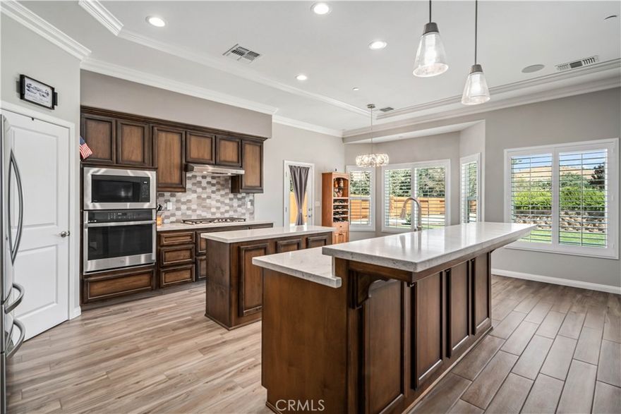 Are you ready to be the second owner of this stunning 2021 custom ranch-style home in the desirable Golden Hills East neighborhood, set on over half an acre with an easy commute to Edwards AFB? This property offers 3 bedrooms + office and 2 bathrooms, with a layout and finishes that feel like a luxury model home. From the moment you arrive, you'll notice the horseshoe oversized driveway, beautiful landscaping, and RV parking with space for multiple vehicles. Inside, enjoy the bright, airy feel with high ceilings, abundant windows, and custom plantation shutters throughout. The home features upgraded flooring, crown molding, tray ceilings in the bedrooms, and elegant custom light fixtures and fans. The gourmet kitchen is a showstopper with two islands, double electric ovens, a gas range, upgraded countertops, and designer backsplash. The split floor plan places the spacious main suite on one side with its huge walk-in closet and luxurious bathroom, while two additional bedrooms and a full bath are on the opposite side for privacy. Step outside to a backyard with over $50,000 in landscaping upgrades including a brick retaining wall, irrigation in the front and back grass, drip lines to the trees, security lighting, and yard drainage from front to back. There's still plenty of room to make the outdoor space your own. And finally, let's talk about the oversized garage — you have never seen one more pristine! With epoxy flooring, an 8-foot door, 10-foot ceilings, and room for larger vehicles, it's a true standout. This home is absolutely immaculate — hurry to this one! Come see it for yourself, there's so much to love.