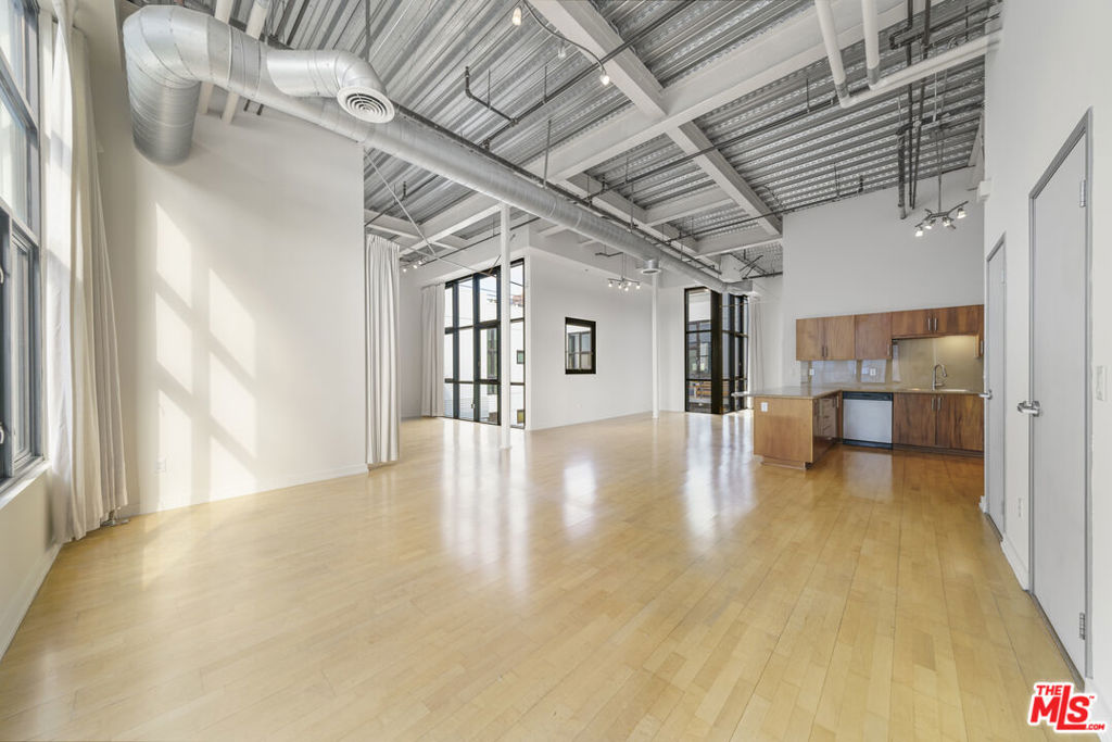 Architecturally unique Penthouse in Vibrant Social District. This spacious, architecturally unique two-bedroom, two-bathroom penthouse is located in the heart of the vibrant South Park neighborhood of Downtown Los Angeles. As you enter, you're greeted by expansive windows, soaring 15' ceilings, and an abundance of natural light, creating an inviting, airy atmosphere.Zoned live-work, the open loft-style floorplan offers the ideal environment for professionals and creatives seeking a versatile space with limitless opportunities. The modern kitchen features stainless steel appliances and a large breakfast bar, perfect for entertaining or enjoying a quiet morning coffee. Both bathrooms are generously sized, each with walk-in closets, providing comfort and functionality. Views overlook the South Park Commons and city lights, with a blend of interior courtyard calm and the energy of DTLA. In-unit laundry completes the convenience of daily living.Built in 1923 and revitalized in 2005, Grand Lofts is a seven-story, sixty-six-unit condo conversion that stands proud among the neighborhood's architectural giants. Residents enjoy resort-style amenities in collaboration with Aven, including an indoor/outdoor gym, multiple BBQ and dining areas, a half basketball court, full beach volleyball court, pool table lounge, private workspaces, dog park, vending and lunch areas, and a true lap pool surrounded by cabanas and skyline views. Parking is assigned and side-by-side at Aven. Outside your door, experience the charm of the neighborhood with a weekly farmers market, nearby parks, cultural hotspots, and trendy hangouts that make this area a dynamic place to live and play. Whether you're seeking a cozy coffee shop, lively nightlife, or world-class dining, it's all within reach. Enjoy easy access to Crypto.com Arena and LA Live, home of the Lakers and an array of concerts, games, and events just minutes from your front door.Great food, great entertainment, and a welcoming community this is South Park living at its best.