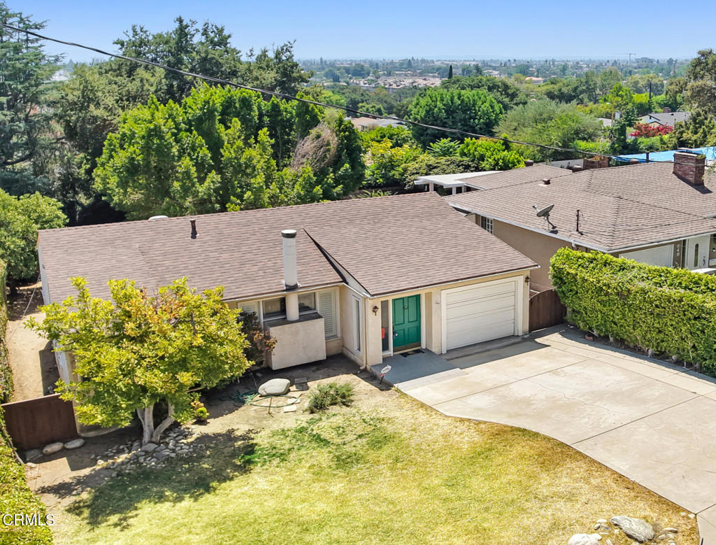 Tucked into the peaceful foothills of Monrovia, this charming 2-bedroom, 2-bathroom home blends classic comfort with outdoor serenity. Step inside to find a spacious living room featuring hardwood floors, crown molding, and a beautiful fireplace flanked by tall windows that fill the space with natural light. The adjacent kitchen is bright and functional, offering granite countertops, ample cabinetry, and direct access to the backyard. Both bedrooms are generously sized, with the primary suite offering mirrored closets and an ensuite bath with a walk-in shower. A bonus room, converted from the garage, provides a perfect space for a home office, studio, or additional storage. Outside, the covered deck offers a quiet retreat for morning coffee or evening gatherings, overlooking a large, private yard dotted with fruit trees and mature landscaping. With a deep driveway, attached garage, and close proximity to nature trails and Old Town Monrovia, this home is a rare opportunity to enjoy foothill living at its finest.