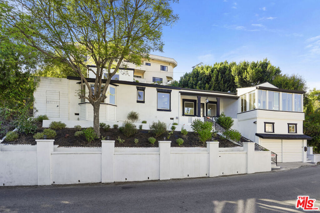 Fabulous 1938 Hollywood Hills Showpiece! Blending vintage charm & Modern luxuries. Nestled on a serene celebrity populated hillside with sweeping mountain views! Showcasing beautiful hardwood floors throughout. A chef's kitchen featuring ample cabinetry, sleek counter tops, stainless steel cook top and oven. The area next to the kitchen exudes with natural light, just chill with a glass of vine and relax after a long day. Center hall plan. There's an office with beautiful mountain views. The primary bedroom opens to an outdoor oasis with privacy a peaceful patio- with fireplace perfect for alfresco entertaining and morning coffee. An exquisite detached guest house, perfect for a nanny, or visiting in-laws or friends. Exceptional proximity to hiking trails, the Hollywood sign. Hollywood Bowl, Runyon Canyon. All major studios, and the famous Universal walk and world class entertainment venues.