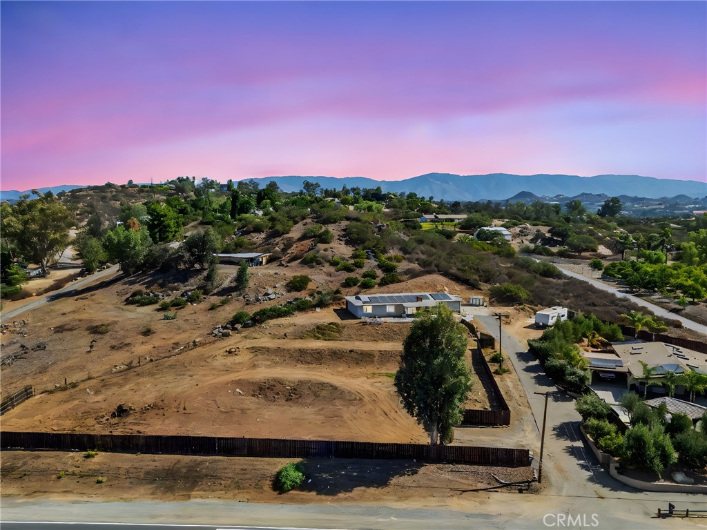 Welcome to this exceptional property offering the perfect balance of country living and modern amenities, perched high atop the rolling hills of Valley Center, California. With stunning views sweeping across the valley, this rare gem provides a peaceful retreat with a true sense of privacy. Situated on a large, well-useable lot. Step inside and be greeted by a single-story, open-concept layout designed for comfort and effortless living. The cozy living area centers around a striking Olympic cast iron fireplace, providing a charming focal point for the space. The heart of the home is the spacious kitchen, which opens seamlessly into the living and dining areas. Large windows allow natural light to pour in, creating a bright, inviting atmosphere. With ample counter space and storage, this kitchen is perfect for preparing meals and entertaining guests. At the rear of the home, a flex/bonus room offers endless possibilities—whether you need an office, workout space, or additional storage, this versatile room can easily adapt to your needs. One of the standout features of this property is the attached living quarters, offering 2 additional bedrooms, an open living area, and a kitchenette. This separate living space is ideal for extended family, guests, or even as a potential rental opportunity. Energy-efficient with solar power, this home is designed to help lower utility costs while supporting sustainable living. Located just minutes from Valley Center's finest restaurants, shopping, and with easy access to the 15 Freeway, this home offers both seclusion and convenience. Don't miss the opportunity to own a truly unique property with breathtaking views and endless potential —a rare gem that combines modern comfort with the charm of country living!