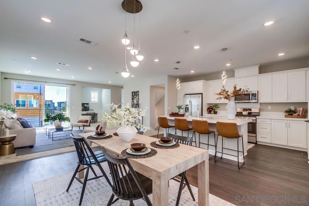 Discover contemporary living in the heart of Millenia! This vibrant community offers effortless access to parks, shopping, dining, and everyday conveniences right outside your door. Step into this stylishly upgraded end-unit (only one wall shared) rowhome featuring 4 bedrooms and 3.5 baths, including a private first-floor suite—ideal for guests, extended family, or a home office.  The kitchen serves as the focal point of the home, complete with white shaker cabinets, quartz countertops, a large center island, and stainless steel appliances. Upstairs, you’ll find three additional bedrooms, including a spacious primary suite with a walk-in closet and spa-inspired bath featuring dual vanities and a soaking tub.  Enjoy built-in energy savings with solar panels, plus the convenience of an attached two-car garage and in-unit laundry. Community perks include a sparkling pool, relaxing spa, and multiple playgrounds. Located directly across from Otay Ranch Town Center and minutes from scenic trails, Otay Lake, and popular eateries like Common Theory Public House and Sura Korean BBQ—this is modern living at its best in one of Otay Ranch’s most sought-after neighborhoods.
