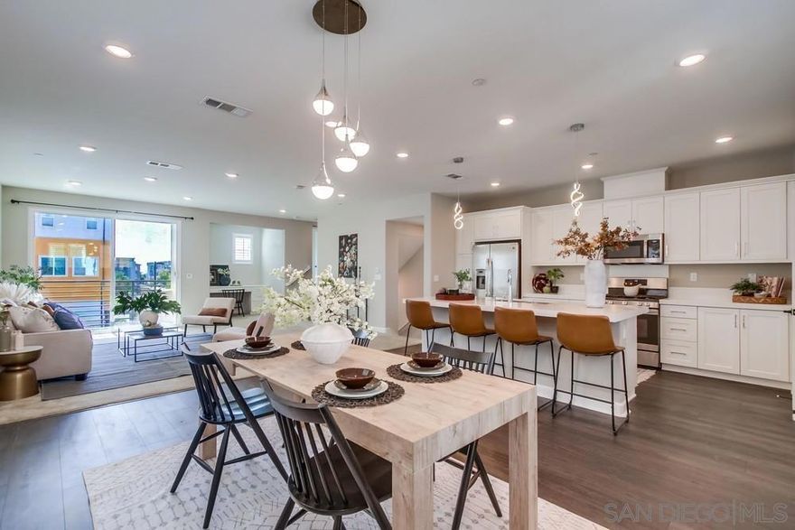 Discover contemporary living in the heart of Millenia! This vibrant community offers effortless access to parks, shopping, dining, and everyday conveniences right outside your door. Step into this stylishly upgraded end-unit (only one wall shared) rowhome featuring 4 bedrooms and 3.5 baths, including a private first-floor suite—ideal for guests, extended family, or a home office.  The kitchen serves as the focal point of the home, complete with white shaker cabinets, quartz countertops, a large center island, and stainless steel appliances. Upstairs, you’ll find three additional bedrooms, including a spacious primary suite with a walk-in closet and spa-inspired bath featuring dual vanities and a soaking tub.  Enjoy built-in energy savings with solar panels, plus the convenience of an attached two-car garage and in-unit laundry. Community perks include a sparkling pool, relaxing spa, and multiple playgrounds. Located directly across from Otay Ranch Town Center and minutes from scenic trails, Otay Lake, and popular eateries like Common Theory Public House and Sura Korean BBQ—this is modern living at its best in one of Otay Ranch’s most sought-after neighborhoods.