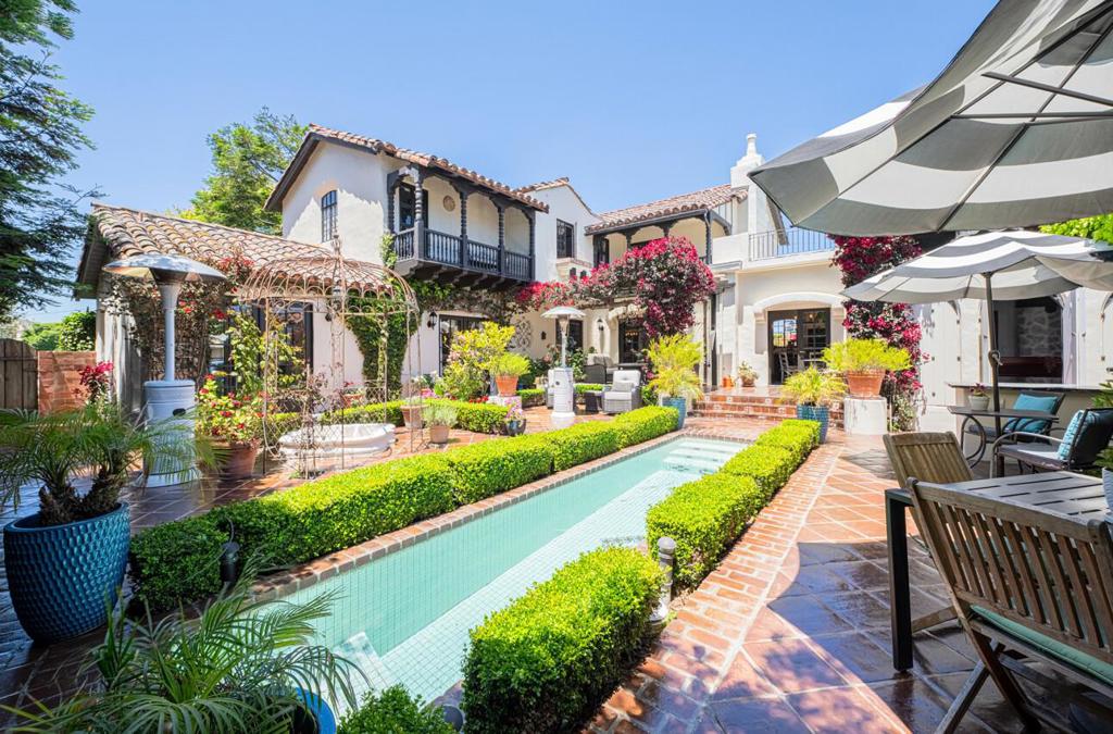 Built in 1930 by Maple Parks developer as the Style Setter Home for Salinas finest neighborhood, this 5 bed, 3 bath (3,998 Sq Ft) Spanish Eclectic is a true architectural gem. Fully remodeled, the home now features a chef's kitchen with Quartzite island, soapstone counters, and custom Tabarca tile backsplash. All bathrooms have been beautifully updated. Historic charm remains with stucco exterior, gabled tile roofs, solid oak floors, wood-beamed ceilings, and classic Mission tile, showcasing exceptional craftsmanship. The main floor includes spacious living, dining, and entertainment rooms, all opening via French doors to the landscaped veranda, enclosed courtyard, and plunge pool. A solarium, office/library, and breakfast nook now featuring a built-in coffee bar with extra storage complete the layout. A broad stairway winds past stained glass windows to bedrooms, each with its own balcony. Also included: a fully permitted (700 Sq Ft) guest house unit with 1 bedroom updated bathroom with a full kitchen living room with fireplace. Combined living area totals (4698 Sq Ft) perfect for multigenerational living or rental income.