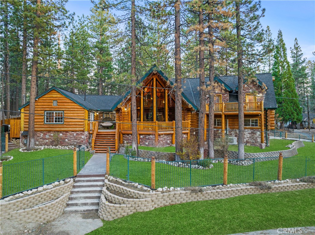 Fabulous Log Home nestled in the heart of Big Bear Valley, a perfect sanctuary to create unforgettable memories with your loved ones. This stunning home boasts a thoughtfully designed interior layout, seamlessly blending formal living and dining areas with inviting and cozy spaces, creating the ultimate entertainer's paradise. Featuring 3 bedrooms, 2 bathrooms, and a total living area of 2,778 sq. ft., this magnificent home offers grand vaulted ceilings, a brand new chef's kitchen adorned with granite countertops and ample cabinet space, a spacious master bedroom, and so much more. The property also includes a large outdoor kitchen, an attached 3 car garage, and a fully fenced yard for added privacy. But the joy doesn't stop there! The sale of this home includes all existing furniture, appliances, TVs, and other items, ensuring that you can move in and start making memories right away. Whether you're hosting lively gatherings year-round or creating cozy family moments, this home provides the perfect backdrop for a vibrant lifestyle. Moreover, this exceptional property is managed by a management company for short-term rentals, generating good amount in rental proceeds while allowing your family to continue enjoying this beautiful home. Don't let this opportunity slip through your fingers - this home is the one you have been waiting for! Reach out to schedule a viewing and let's turn your dream of owning a luxurious log home into a reality.
