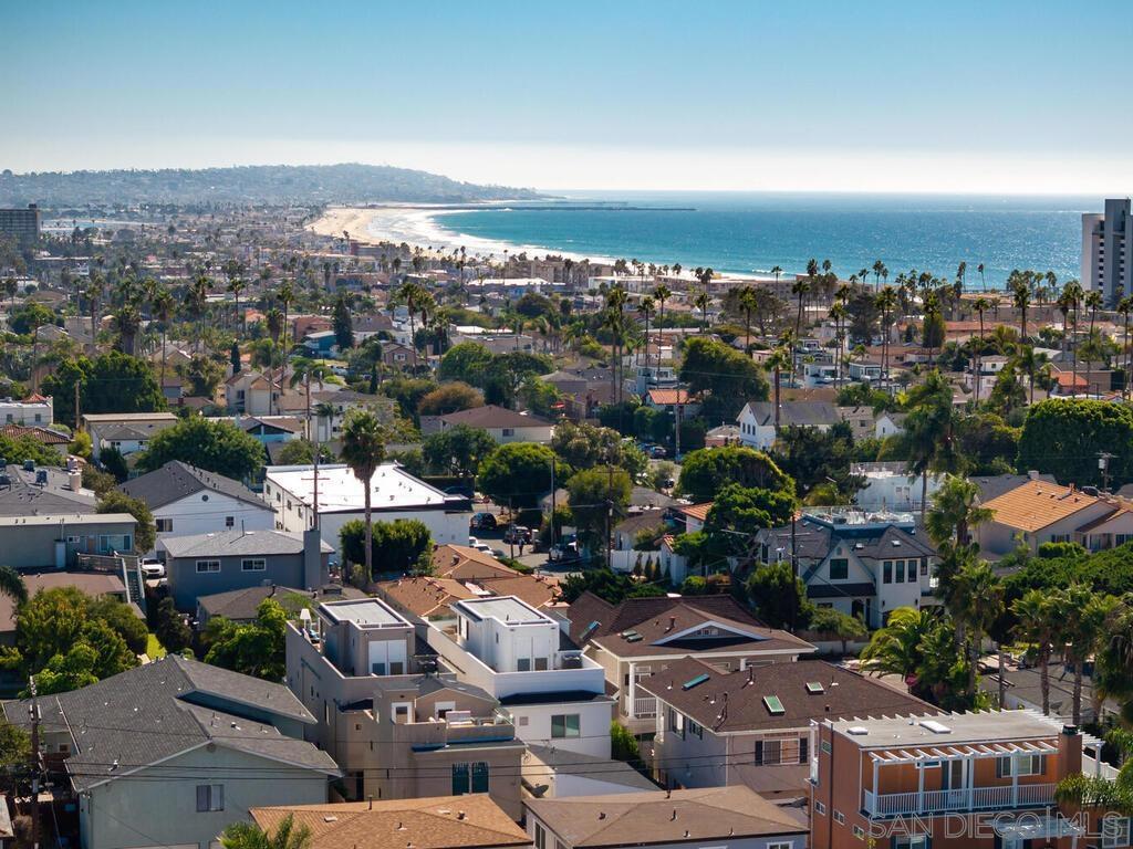 Pacific Beach at its best! Built in 2018, this modern coastal home has been immaculately maintained, boasts high end stainless appliances and designer finishes throughout, and comes with an open and intelligent floor plan perfect for formal entertaining or just casual day to day beach living. The recent addition of a detached, fully permitted 1BR, 602sqft ADU complete with separate entrance and its own private roof deck, only adds to the flexibility of this offering. Three blocks to the beach, walk to restaurants, shops, and both elementary and middle schools. Enjoy bay, ocean and coastline views south to the Coronados. See supplement for more property details...  The main house is 2331sqft, with 3BR/3.5BA, an optional den/family room/office on main floor and an additional suite on the 3rd level with full bath, wet bar area, wine fridge, and expansive deck with fireplace and views of the coastline to the south.  Finishes include shaker cabinets in the kitchen, quartz counters, Jenn-Air extra wide range with hood and pot-filler and custom back splash.  La Cantina doors open from the family room to the front patio, while large wall to wall sliders open the living area to the back yard patio providing a seamless flow of indoor/outdoor living.  The master suite has its own private lanai, fireplace, walk in closet and bath with custom tile work and fixtures, rainfall shower and separate tub.  There's a 2-car detached garage off the alley with ample height for overhead storage.  Above the garage sits the newly constructed ADU, providing an additional 602sqft (as per plans) of living space with the same quality of finishes as the main house.  The ADU has its own private entry, separate bedroom from living area, laundry closet and a good sized private roof deck with views.