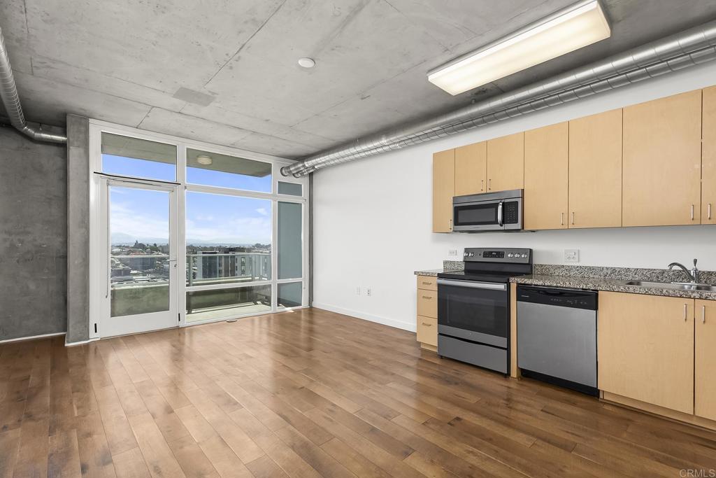 Welcome to the 15th floor of Smart Corner, where modern design meets unbeatable city views. This studio features an open-concept layout, perfect for today’s lifestyle. Industrial-chic touches like exposed concrete, sleek hardwood flooring, and floor-to-ceiling windows create a bold, contemporary feel. Step out onto your private balcony and take in panoramic vistas of Balboa Park, the mountains, Coronado Bridge, and beyond. The unit comes equipped with a refrigerator, dishwasher, electric range, in-unit washer and dryer, and includes one underground parking space. Smart Corner residents enjoy exclusive access to a spectacular rooftop lounge featuring BBQ grills, a hot tub, and a community garden all set against sweeping skyline and ocean views. Located next to City College with immediate access to the Trolley and major freeways, this VA-approved building puts the entire city within reach. Don't miss your chance to live in one of East Village’s most desirable high-rises where style, convenience, and views come together.