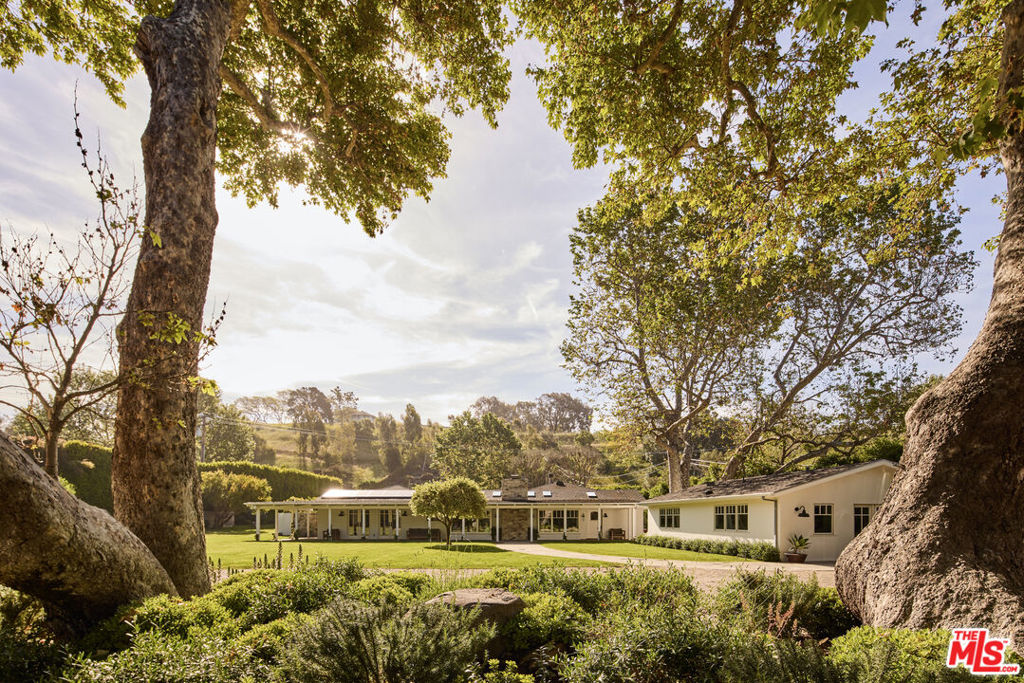 Nestled in the heart of Bonsall Canyon - one of Malibu's most prized enclaves known for its tree lined streets and close proximity to Point Dume and Zuma Beach - this single-story ranch retreat offers a seamless blend of refined design and relaxed coastal living. Set on 1.6 acres, the 5,261 sq. ft. estate includes a 3-bed, 3.5-bath main house and a 1-bed, 1-bath guest house, both finished with hardwood floors and high-end fixtures. At the heart of the home, a chef's kitchen flows effortlessly into open living spaces, creating an atmosphere of understated elegance and everyday comfort. French doors reveal a sprawling backyard oasis - anchored by a 50-foot freshwater pool with diving board, solar/gas heat, and outdoor showers. A fully equipped Viking kitchen, gas fire pit, and illuminated putting green elevate the experience, blurring the line between indoor sophistication and Malibu's open-air beauty. The primary suite is a serene retreat, with garden views, dual closets, and a spa-inspired bath complete with a steam shower and radiant heated floors. Thoughtfully designed for both comfort and indulgence, it offers a quiet sanctuary in the heart of this exceptional property. With solar panels, four Tesla Powerwalls, a tailored irrigation system linked to a grandfathered well, ensuring vibrant, lush grounds throughout the year, the estate captures the essence of Malibu where natural beauty, elegant design, and laid-back luxury meet. This is a rare opportunity to own a private sanctuary in one of Malibu's most prestigious and peaceful settings.