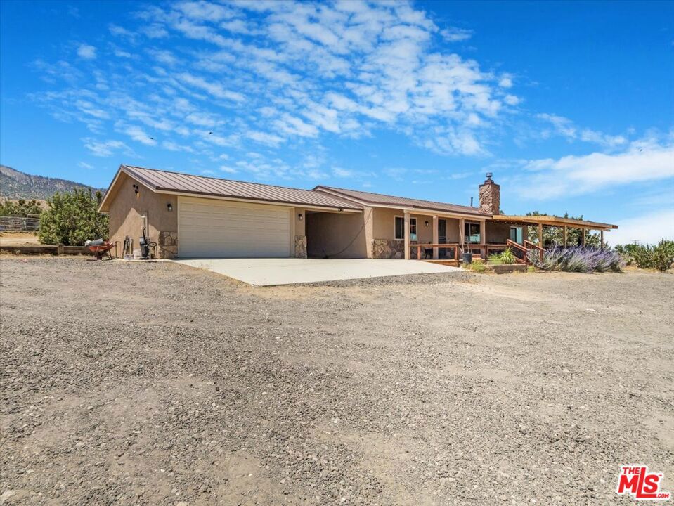Welcome to your peaceful retreat in Pinon Hills! This charming 3-bedroom, 2-bathroom home sits on 1.73 acres of open land, ideal for those seeking both comfort and space. Enjoy a relaxing front porch where you can take in the quiet surroundings and relaxing views. Inside, the open floor plan features a cozy wood-burning fireplace, modern laminate flooring, and a kitchen with stainless steel appliances that flows seamlessly into the dining and living areas perfect for easy everyday living. The primary suite includes a remodeled bathroom with dual sinks and a spacious walk-in closet with custom organizers. All bedrooms offer carpeting and modern blinds. Recent upgrades include a durable metal roof, energy-efficient windows and doors, a newer HVAC system, and a smart thermostat. Step outside and embrace the wildlife, open skies, and snowcapped mountains during winter. There's space for chickens, RV hookups, a detached 2-car garage, and two large storage sheds. The backyard is enhanced with flower beds and a retaining wall. Located on a paved road in a welcoming neighborhood with great access to highwaysjust minutes from local schools and shopping. This home truly has it all!