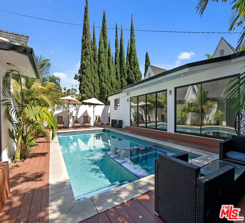 This property is available for short-term and long-term rentals, each with its respective pricing options. It is fully furnished, decorated, and equipped with hotel-like essentials and amenities. With our concierge team available to assist 24/7, this home rental offers a five-star hospitality experience, whether you are staying for a few days, a month, or a year. Step into the lap of luxury at this stunning entertainer's dream home, perfectly situated in the heart of Los Angeles. This designer-finished property offers both style and function with an airy open floor plan, sophisticated touches, and a peaceful, private ambianceall just moments from 3rd Street, The Grove, and LA's finest restaurants and shopping. The main house features 4 spacious bedrooms and 3 sleek bathrooms. Soaked in natural light, the living room boasts a modern fireplaceperfect for cozy evenings. The gourmet kitchen is a chef's paradise with custom cabinetry, a generous island, and top-of-the-line appliances, ideal for both cooking and entertaining. Retreat to the master suite, where you'll wake up to views of the pool and enjoy direct access to the lush backyard. The master bath is pure indulgence with a steam shower, soaking tub, and double vanities. Adding to the appeal, a separate guest house provides 1 bedroom, 1 bathroom, and a fully equipped kitchen perfect for extra privacy or extended stays. Outside, escape the city in a serene backyard oasis surrounded by lush landscaping. Lounge by the pool, dine al fresco, or simply relax in total tranquility, it's hard to believe you're in the middle of LA. Whether you're here for work, play, or a little of both, this home has it all: luxury, convenience, and comfort in one unforgettable stay.