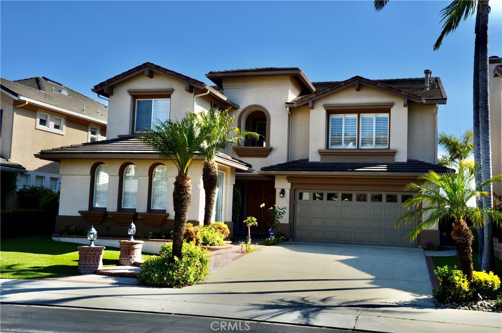 Perched on a premium view lot, this executive-class residence boasts ever-changing valley, hill, and city light views that culminate in extraordinary sunsets. The backyard, designed for entertaining, features a built-in BBQ, seating area, and a shaded patio. The inside spans approximately 3,812 square feet. The main level impresses with a grand formal entry, soaring two-story ceilings, and an abundance of natural light. A gourmet kitchen complete with charming cabinetry, a center island, granite countertops, walk-in pantry, and newly upgraded stainless-steel refrigerator, oven and microwave that functions as a convection oven. A cozy breakfast nook opens to the inviting family room with a fireplace. The home’s two primary suites provide luxury and privacy. The main-level suite features a private entrance and retreat area, while the second-level suite boasts a private view balcony, jetted tub, oversized shower, double vanity sinks, and a large walk-in closet with pull-down attic access for extra storage. Two ensuite guest bedrooms and an oversized den/entertainment room with built-in cabinets and a fireplace complete the second level. This home is packed with modern upgrades, including newly installed carpet on stairs and guest bedrooms, flooring on main living areas and primary suite on second level, and recess lighting in family room. Additional highlights include solar panels, new AC and heating systems, central vacuum, reverse osmosis filtration, a water softener, and a garage with built-in cabinets, overhead storage, and an instant hot water heater. The San Joaquin Hills community offers resort-style amenities, including two pools and hot tubs, a gated playground, picnic area, a basketball court, and 24-hour guard-gated security. Located just a short drive from world-class beaches.