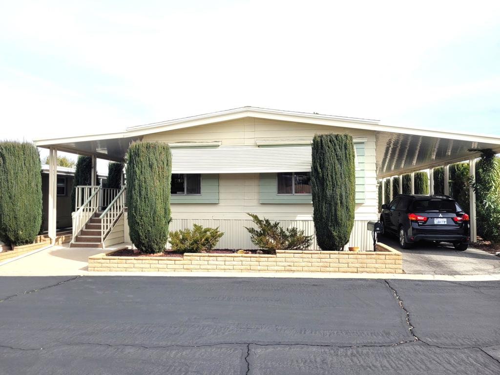 This 1977 triple-wide mobile home by Lancer, with 1590 square feet, has been beautifully updated and modernized. Improvements made in Fall 2024 include new laminate flooring throughout, a new HVAC system, a new roof, new stainless steel appliances in the kitchen as well as new countertops and sink, and fresh paint throughout, both exterior and interior. Entry to the home, through the newly carpeted west-facing deck with mountain views, leads into large and bright living room and adjacent dining area. A short hallway leads to the kitchen and spacious family room with sliders out to the deck. Opposite is the laundry room with full-size W / D and utility sink. The guest bath is accessed via the laundry and the adjacent guest bedroom has a reach-in closet with useful built-in storage. The primary bedroom, at the rear of the home, is spacious and light, also has a reach-in closet with built-in storage; the ensuite primary bath has a lovely vanity and garden tub with a door to the separate commode and shower stall. Access to the large additional room on the west side of the home is through a door at the end of the front deck; this room, currently used as storage, has a utility sink and is fully vented for A/C and heat. There is a large outdoor storage shed on the premises, parking is tandem under the carport on the east side of the home. Space rent for the new owner of this gracious residence will be $750 per month; park approval is required to complete any purchase.
