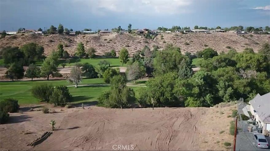 Raw land that slopes down into the golf course. Small amount of vegetation.
