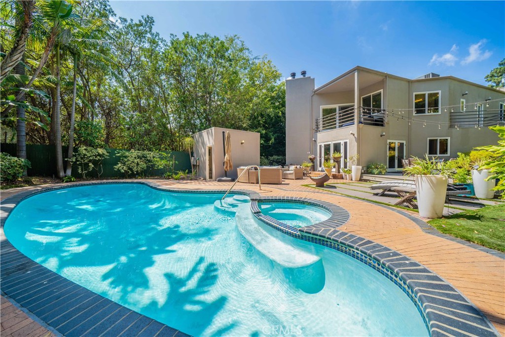Tucked in the Hollywood Hills and within the coveted Wonderland school district, this 4BD/5BA home blends comfort and charm with hillside serenity. The light-filled layout features tasteful updates throughout, a chef's kitchen which features granite counters, wine fridge, a double oven with warming drawer and two dishwashers and stainless appliances. Kitchen opens seamlessly to a spacious deck for al fresco dining, a cozy media room with Art Deco flair, and a primary suite with a giant tub and oversized shower. Upstairs, three bedrooms each enjoy their own en suite bathroom and large closets with thoughtfully designed buildouts. Each of these upper rooms boast expansive windows and private balconies that bring in hillside breezes and natural light, creating a tranquil atmosphere in every corner. Outdoors, the property transforms into a private sanctuary. Lush landscaping surrounds a sparkling pool and spa, complemented by a pool house complete with bath, shower, and changing area. Gather around the fire pit, enjoy the soothing ambiance of a water fountain, or host memorable get-togethers in multiple inviting spaces designed for connection and relaxation. Downstairs 4th bedroom is being used as an office and media room could be converted to a 5th bedroom. Behind gates, this home offers both privacy and proximity - an elegant retreat just minutes from the best of Los Angeles dining, shopping, and culture. A rare chance to enjoy the perfect mix of charm, character, and Laurel Canyon lifestyle just minutes from the Sunset Strip.