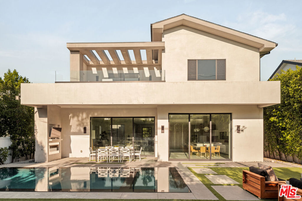 A sophisticated fusion of modern architecture and serene luxury, this newer construction contemporary home features 5 en-suite bedrooms, soaring 12-24-foot ceilings, dramatic floor-to-ceiling pocket doors, and a seamless indoor-outdoor flow in the heart of prime Studio City. The expansive open floor plan creates a sunlit atmosphere with seamless indoor-outdoor connectivity. At the heart of the home lies a chef's kitchen outfitted with custom cabinetry, premium appliances, and an oversized center island ideal for everyday living and effortless entertaining. Italian porcelain tile, bespoke lighting, and carefully curated finishes lend warmth and elegance throughout. The living areas flow into a private backyard retreat featuring a sparkling heated pool, outdoor kitchen, covered dining area, and a striking 14-foot water wall offering a true sense of tranquility and escape. Additional amenities include a custom home theater and a glass-enclosed wine display, bringing a refined lifestyle touch to the residence. Upstairs, four ensuite bedrooms are centered around a bright, open landing, including the luxurious primary suite with its own fireplace, spa-inspired bathroom, generous walk-in closet, and a private balcony overlooking the lush, Zen-like grounds. Featuring a large flat lot, the backyard showcases a zero-edge pool, outdoor kitchen, and turfed lawn, perfect for entertaining and lounging. The 2-car garage has been conveniently converted into a state-of-the-art gym, perfect for fitness enthusiasts. Ideally located just moments from Tujunga Village and Studio City's most beloved boutiques and cafes, this thoughtfully designed home embodies the essence of elevated California living.