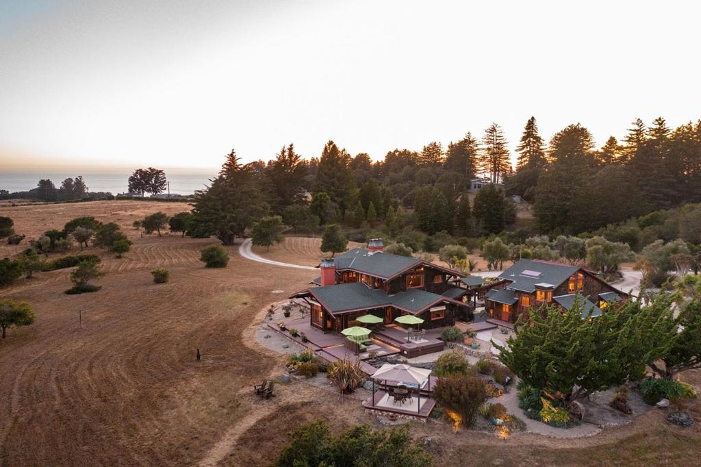 This exceptional property is in one of the most exclusive neighborhoods between Santa Cruz and Half Moon Bay, along a gated private road with great views of Monterey Bay and the Pacific Ocean. It is secluded and serene, yet it is only 5 minutes from Highway 1, 15 minutes from Santa Cruz, and 90 minutes from San Francisco. The property covers 11 acres of flat, open land and has 2 legal parcels. It features a romantic, contemporary Craftsman home (2400 sq.ft.) connected via a courtyard with a guest house (1800 sq.ft.), surrounded by extensive gardens, patios, and decks for outdoor entertaining. A modern kitchen opens to a spacious dining room and a living room with sweeping views over a coastal meadow frequented by wildlife. The main bedroom has a walk-in closet and a bathroom with ocean views. The guest house has 2 bedrooms, 2 full baths, a library, kitchenette, and a large living space. The property has a caretaker's studio (400 sq.ft.), a garage and workshop (1000 sq.ft.), and other outbuildings. It has a modern infrastructure with high-speed internet and backups for communications, power, water, and fire safety. The property is 500 feet above sea level and 2 miles from the ocean, close enough to hear the surf at night, but far enough inland to be sheltered from the wind.