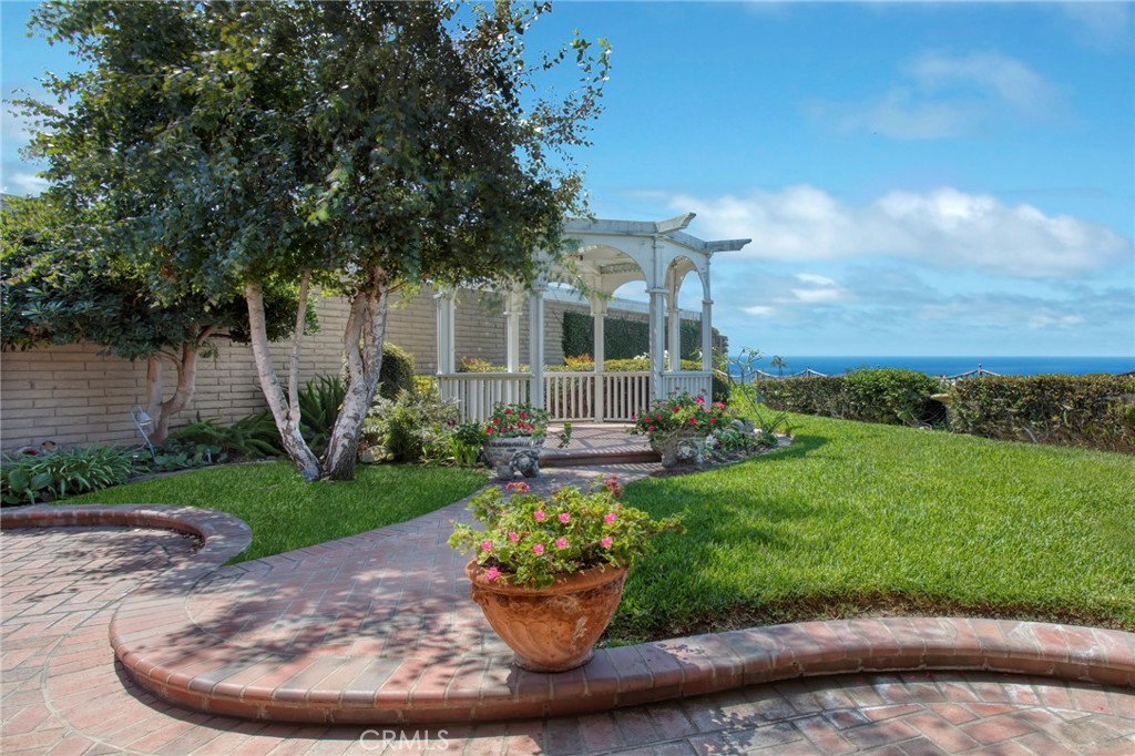 Located on the beachside of Coast Hwy in the 24-hour gated oceanfront community of Niguel Shores, this one-story "BEACH HOUSE" offers the ultimate coastal lifestyle. Perched on a premium cul-de-sac lot, with only 3 homes on this street, this property spotlights a lovely ocean and sunset view, a large front gated courtyard and large back yard with built in BBQ, lush landscape and just minutes to the sandy beach. With ocean views from all main rooms, this home has been expanded with a center fireplace surrounded by family, living and dining areas, an open kitchen concept complete with granite counters and stainless steel appliances, 3 Bedrooms, 2 Baths, large walk-in finished closets, an inside laundry area which leads to the 2-car attached Garage. The primary bedroom opens to the ocean view and garden patio and includes a built-in office work space. Recessed lighting, vaulted ceilings, new paint and carpet, plus lovely brick patio areas highlight the charm of this seaside gem. The spacious back yard is ready for entertaining a crowd or just relaxing in the tranquil setting. Homes in this area and on this street are rarely available. Niguel Shores includes an oceanfront blufftop park and parking lot with direct beach access and a wonderful Clubhouse with pool, spa, pickleball, tennis, sports courts, park and more. The community of Niguel Shores is situated next to the Ritz Carlton Hotel and is minutes close to the Marina at Dana Point, the Waldorf-Astoria Monarch Beach Resort, the Links Golf Course, and to the Art Colony of Laguna Beach. Enjoy the fun and festive beach lifestyle all year around in NIGUEL SHORES...The "Best-Kept" Secret Along The Coast!