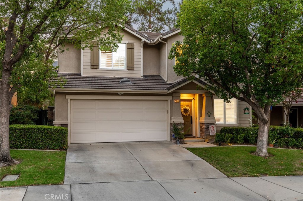 Beautifully remodeled home in the private gated community of Sundance II, offering stunning views of Los Serranos Golf Course. Perfectly situated across from the community park, the property features a manicured front yard with lush grass, mature shade trees, hedges, and a welcoming covered front porch. Inside, luxury vinyl plank flooring flows from the entry into the living room with plantation shutters and recessed lighting. The remodeled kitchen features white cabinetry, granite countertops, travertine backsplash, stainless steel appliances, a center island with seating, and a sliding door that opens to the backyard. The adjoining family room includes a custom fireplace, dry bar, recessed lighting, and shuttered windows with backyard views. A versatile downstairs bedroom, currently used as a den/library, sits near a custom half bathroom and the laundry center. Upstairs, a spacious loft (potential 5th bedroom) serves as an ideal second family room. The primary suite features golf course views, a ceiling fan, walk-in closet, and a remodeled bathroom with dual vanities, quartz counters, a framed mirror, a walk-in shower with frameless glass, and a separate soaking tub. Two additional bedrooms and an updated hall bathroom complete the upstairs. The backyard is designed for entertaining with an Alumawood-covered patio, concrete decking, a brick and stacked-stone accent perimeter wall, artificial turf putting green, and professional landscaping. Mature trees behind the home create privacy while still allowing for scenic golf course views. There is also an electric car charger outlet in the garage.