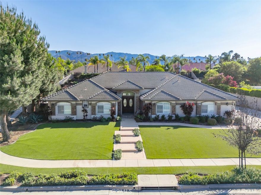This expansive single story home, located in desirable South Corona neighborhood, has all the upgrades and features you're looking for a luxurious and comfortable style of living. Four bedrooms plus an office, three and a half bathrooms, formal living and dining, and expansive kitchen and adjacent family room are spread over nearly 4,000 square feet, located on a half acre lot. Enjoy entertaining at the formal living and dining room with 14-foot coffered ceilings. The chef's kitchen features Thermador appliances: six burner gas range, double ovens, and built-in refrigerator. There's also a wine refrigerator, Miele coffee maker, and walk-in pantry. Decora cabinets with soft-close doors and drawers line the kitchen, topped by gorgeous marble counters. And the prep island has a conveniently located drawer microwave. All rooms are generously sized, notably the family room with space for a pool table and the primary suite with fireplace and sitting area. The primary suite has a spacious walk-in closet and remodeled bath with oversized shower and free standing tub. Stepping outside, you'll have the luxury of a covered outdoor fireplace and kitchen with newer Twin Eagles gas grill, refrigerator, and bar seating which comfortably seats eight. And enjoy the convenience of gated RV parking with upgraded electrical outlet and easily fits a 55-foot RV. Other notable features include custom shutters and wood blinds, a whole-house vacuum system, new water softener and 75-gallon water heater, epoxy flooring and storage cabinets in the garage, and two outdoor sheds. Located just a short distance to award winning schools including Susan B Anthony Elementary and Santiago High School. And Santana Regional Park is just a few blocks away.