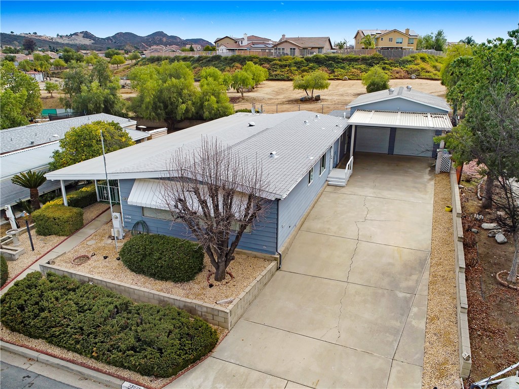 A Great turnkey Manufactured home in The Farm Community located off Bundy Canyon Road with easy access to 15 and 215 highways, This home has 3 bedrooms, 2 baths, Family Room with large bar, Office area, Living room. Great RV garage with FULL RV hookups, plus 2 car tandem or one car with workshop area 2 floor area and storage for most anything like toys or place to run your business from with long driveway and a car port. Remodeled Kitchen has xtra large pantry, cabinets with built in lazy susan. Large covered patio on the front of the home. An oversized central air conditioning and a swamp cooler. Outside, you will enjoy a nice covered front porch, plus a driveway side entrance through the indoor laundry room with sink. The yard is fully landscaped front and back and has sprinklers and drip system. The Backyard has a covered patio and is fenced with gate access to the front yard, side yard, and open land behind the property (no neighbor directly behind you). Major earthquake bracing with marriage bars, laminate flooring, waste disposal, whole house surge protector. The community has multiple pools, spa, community fruit trees, hiking trails, baseball field, tennis court and picnic area with playground and a pond for fishing or just enjoying while sitting on the benches watching the ducks. This is a must see! Low maintinance yards. Turnkey for modern living with an open concept.